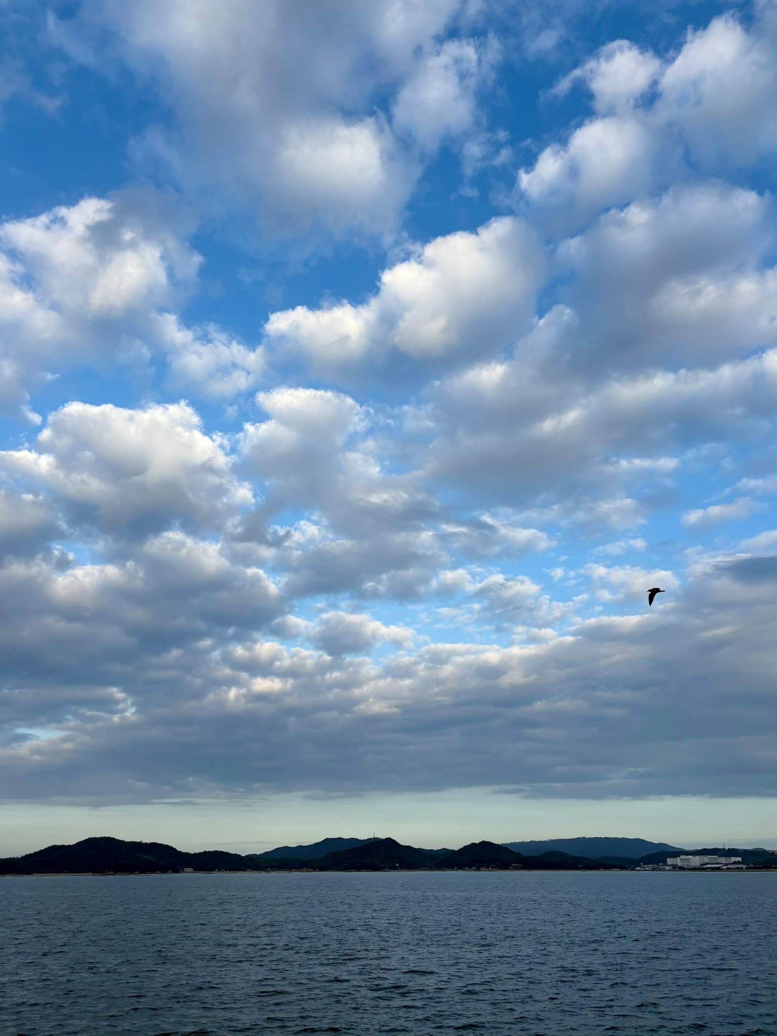 青空と白い雲が広がる海の風景 島々が遠くに見える