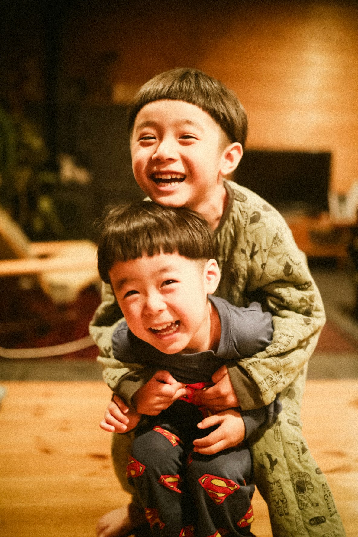 children hugging and smiling indoors