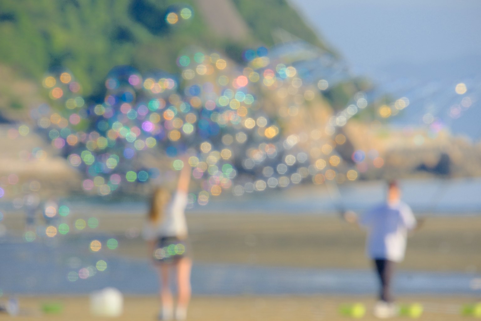 해변에서 비눗방울을 가지고 노는 아이들