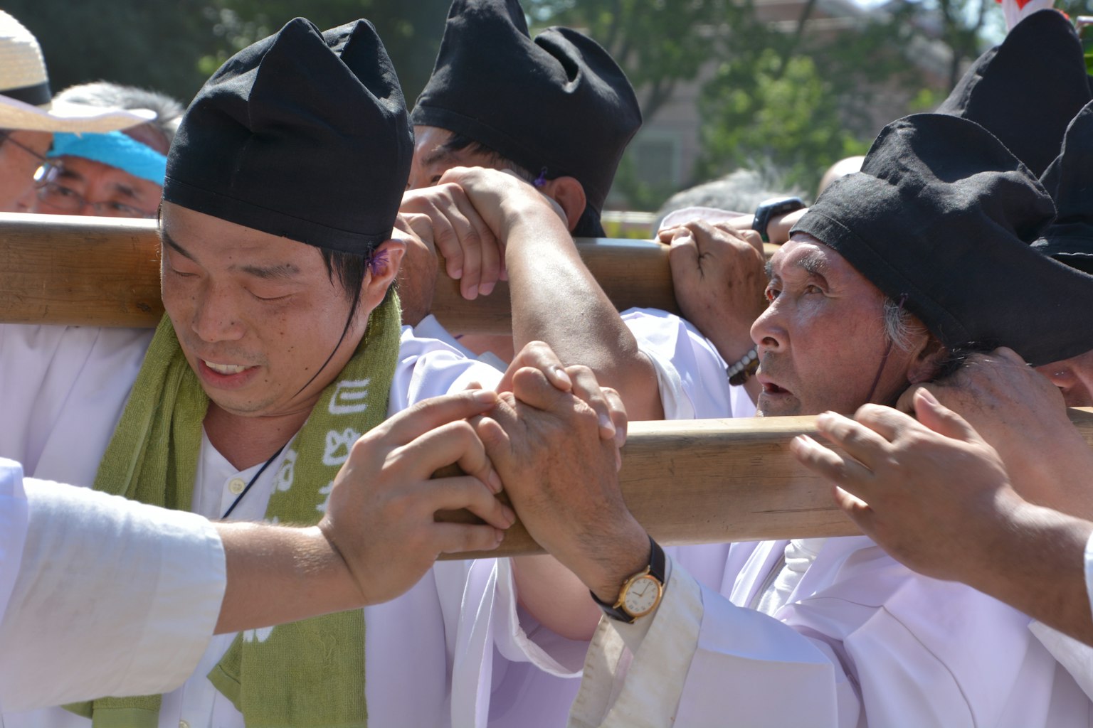 Hombres levantando un palo de bambú durante un festival tradicional