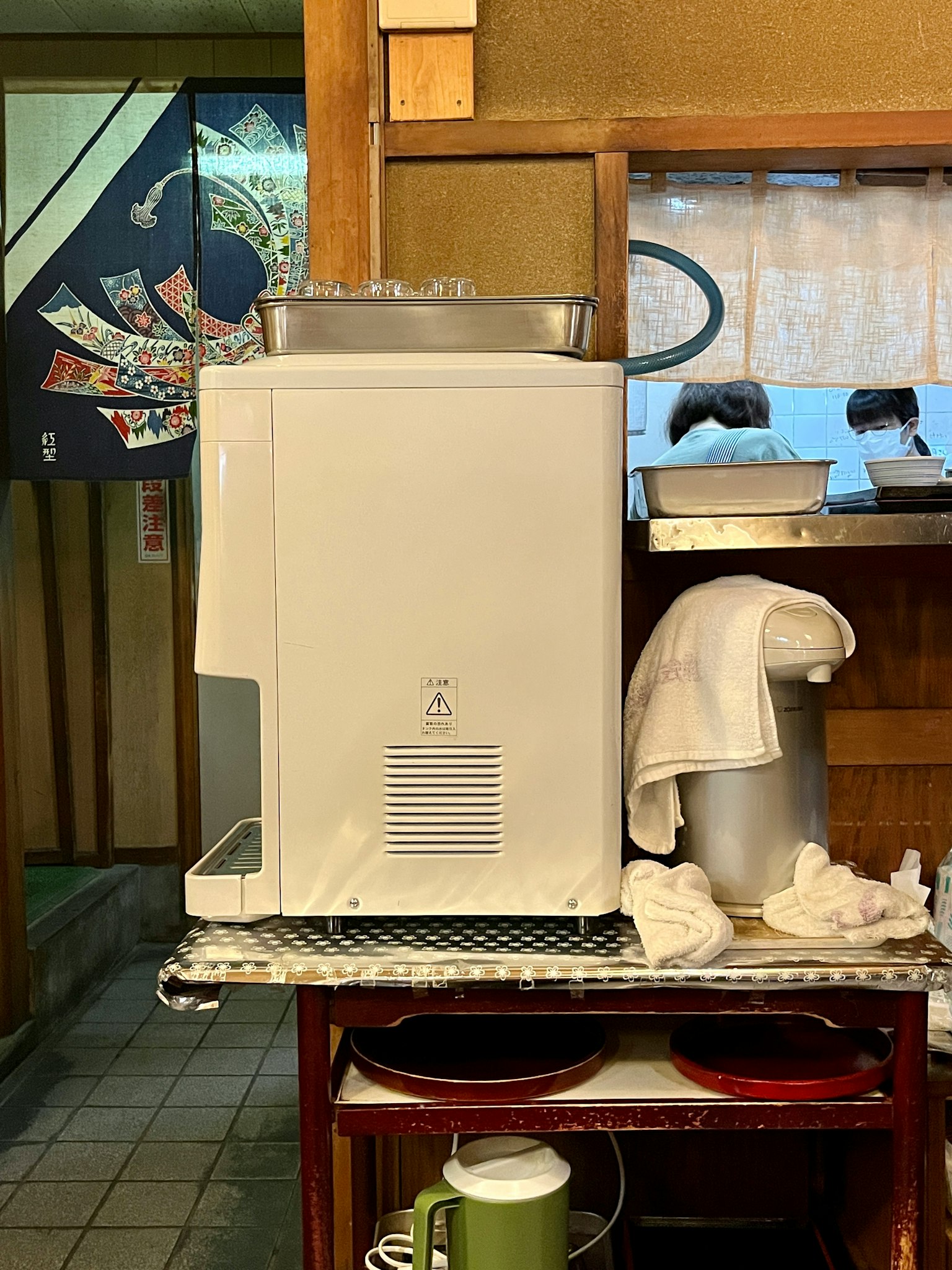 傳統日本餐廳櫃檯上的白色飲水機和毛巾