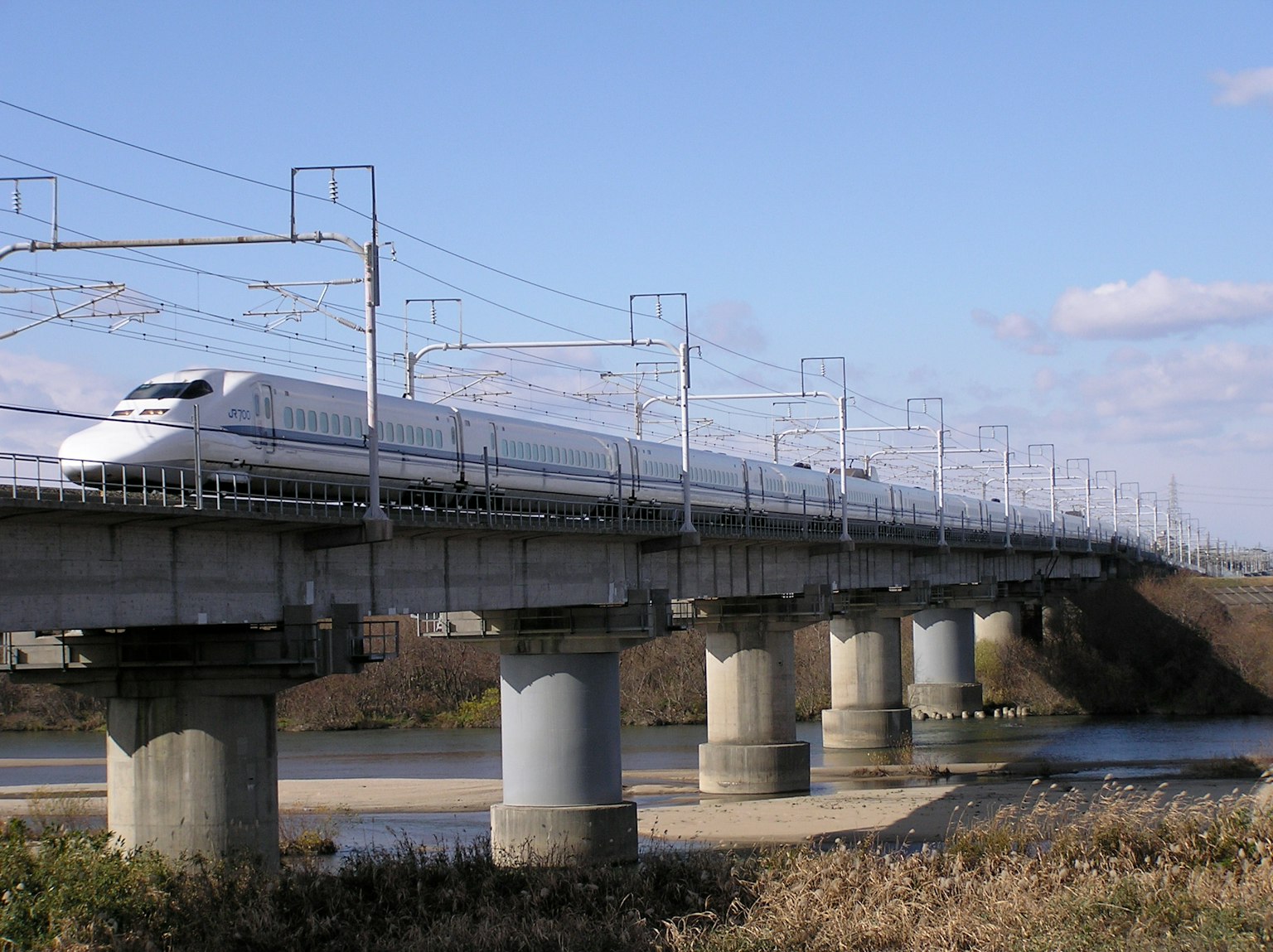 Shinkansen traversant un pont au-dessus d'une rivière