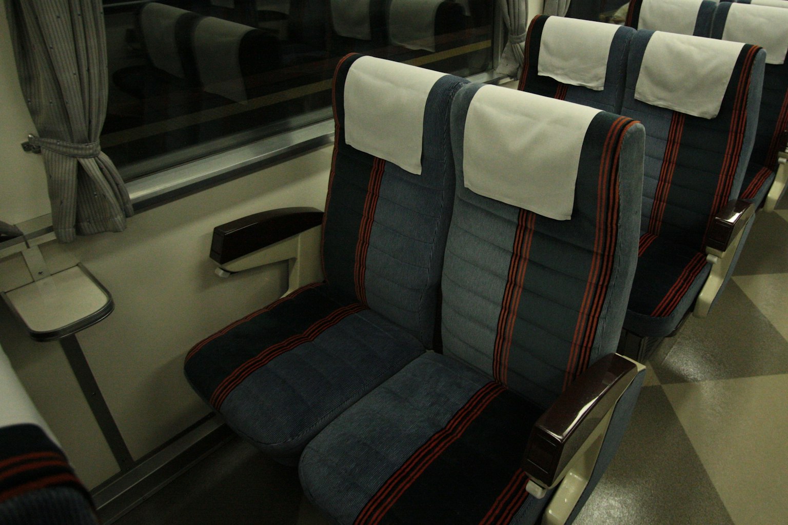 Interior de un tren con asientos a rayas azules y rojas