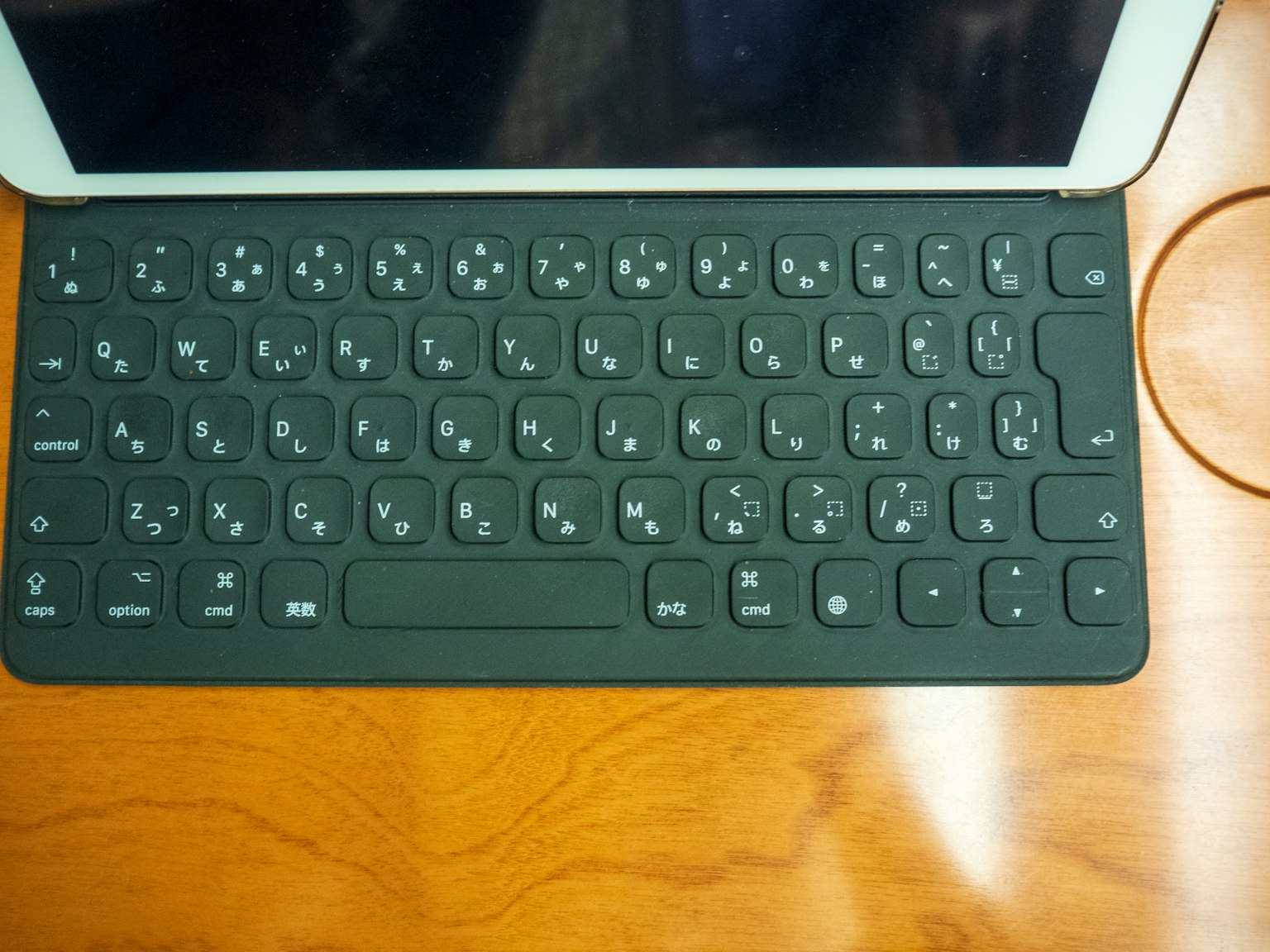 Black keyboard placed on a wooden table