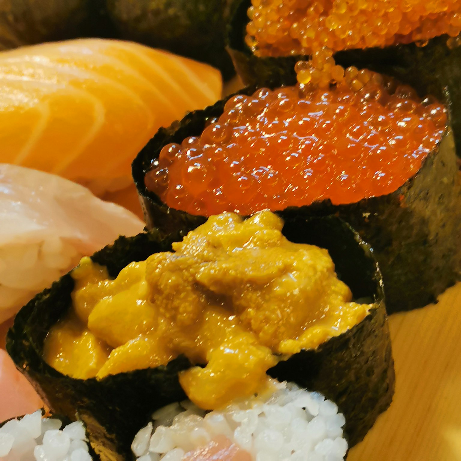 Primer plano de un plato de sushi con nigiri de ikura y uni