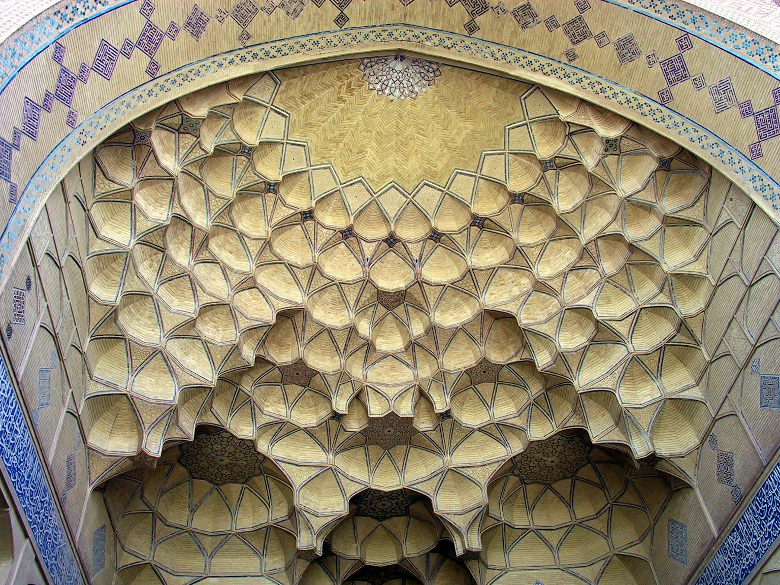 Techo de arco decorativo con intrincados patrones geométricos en tonos amarillos y azules