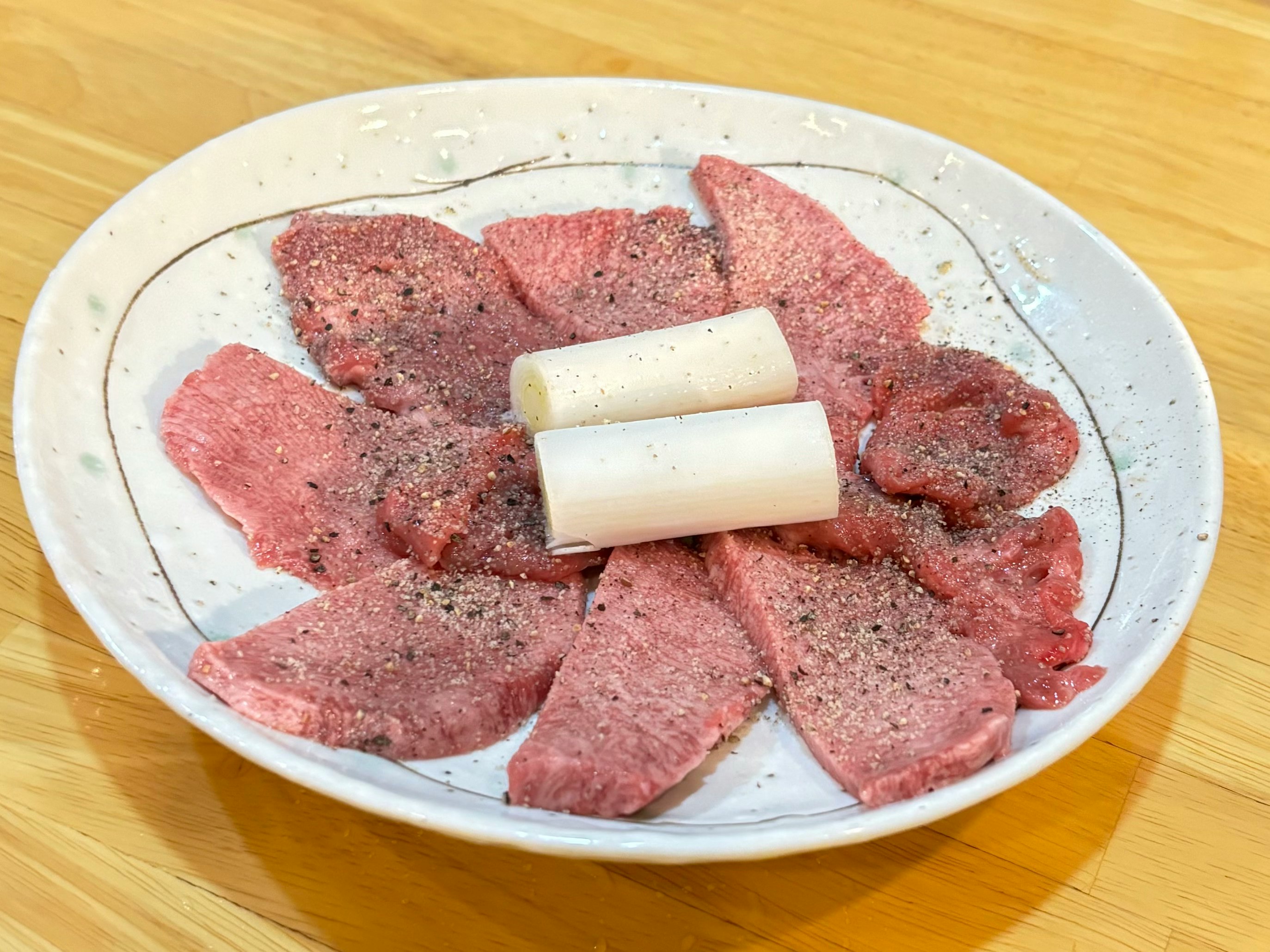 sashimi di carne rossa cruda con grasso bianco su un tavolo di legno