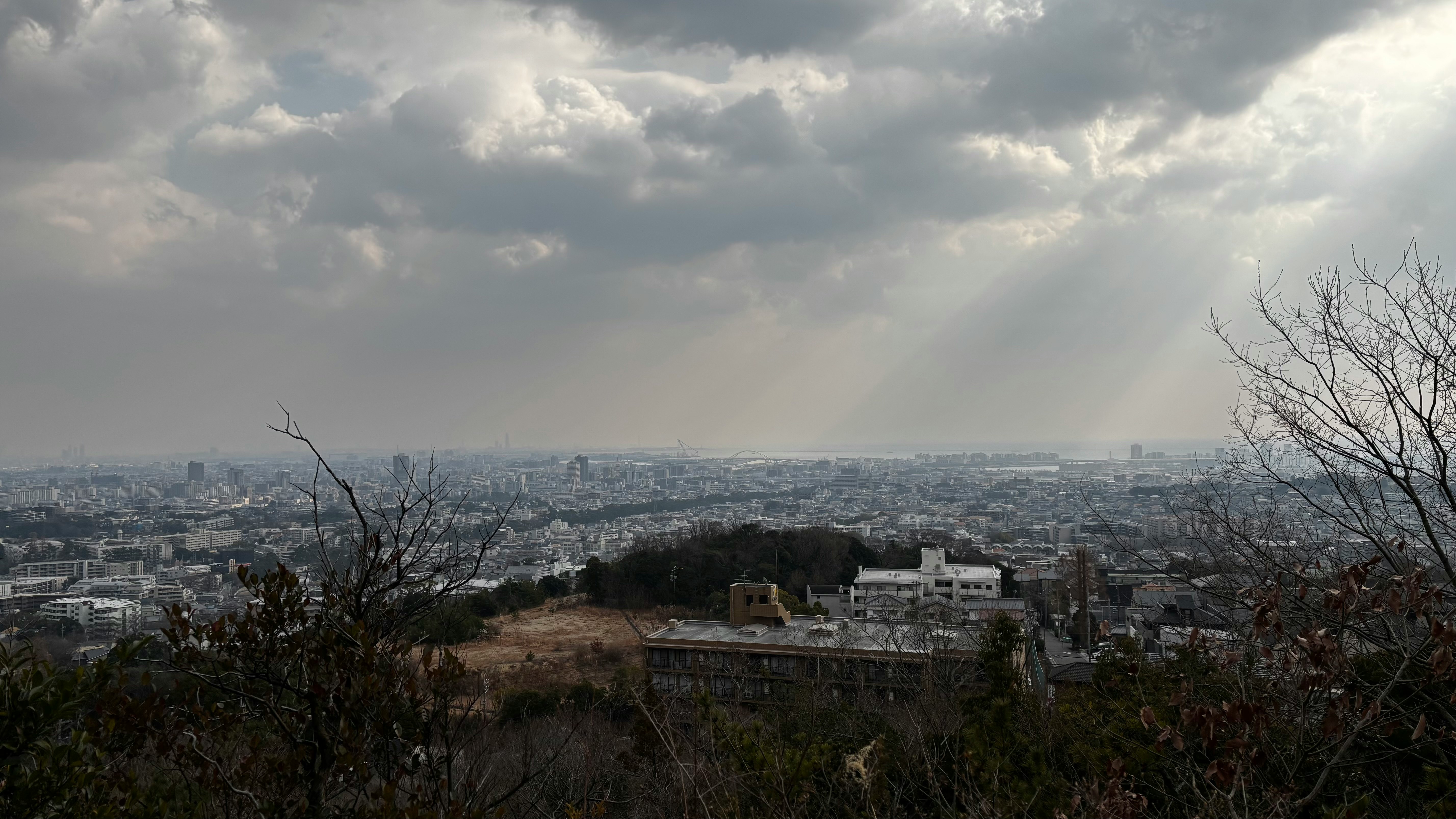 panorama di una città da una collina sotto un cielo nuvoloso