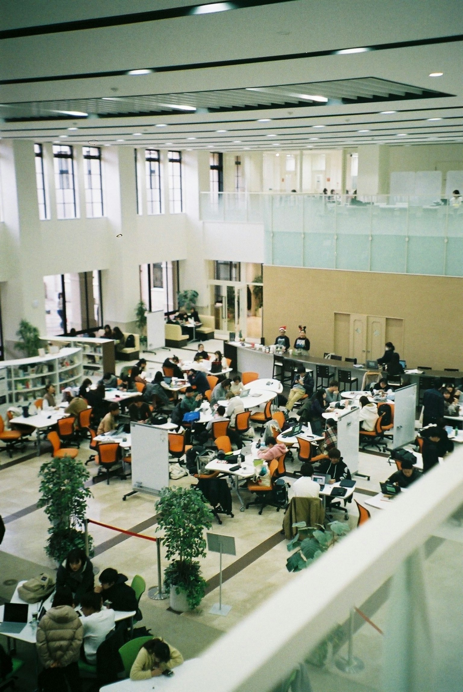A spacious library interior filled with students at study tables