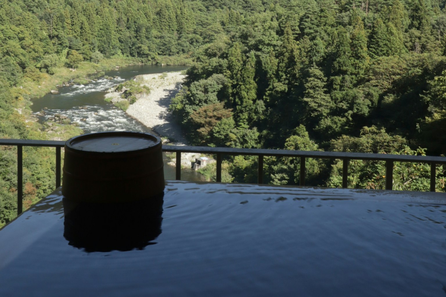 Vista panoramica di una sorgente termale che si affaccia su un fiume e una foresta