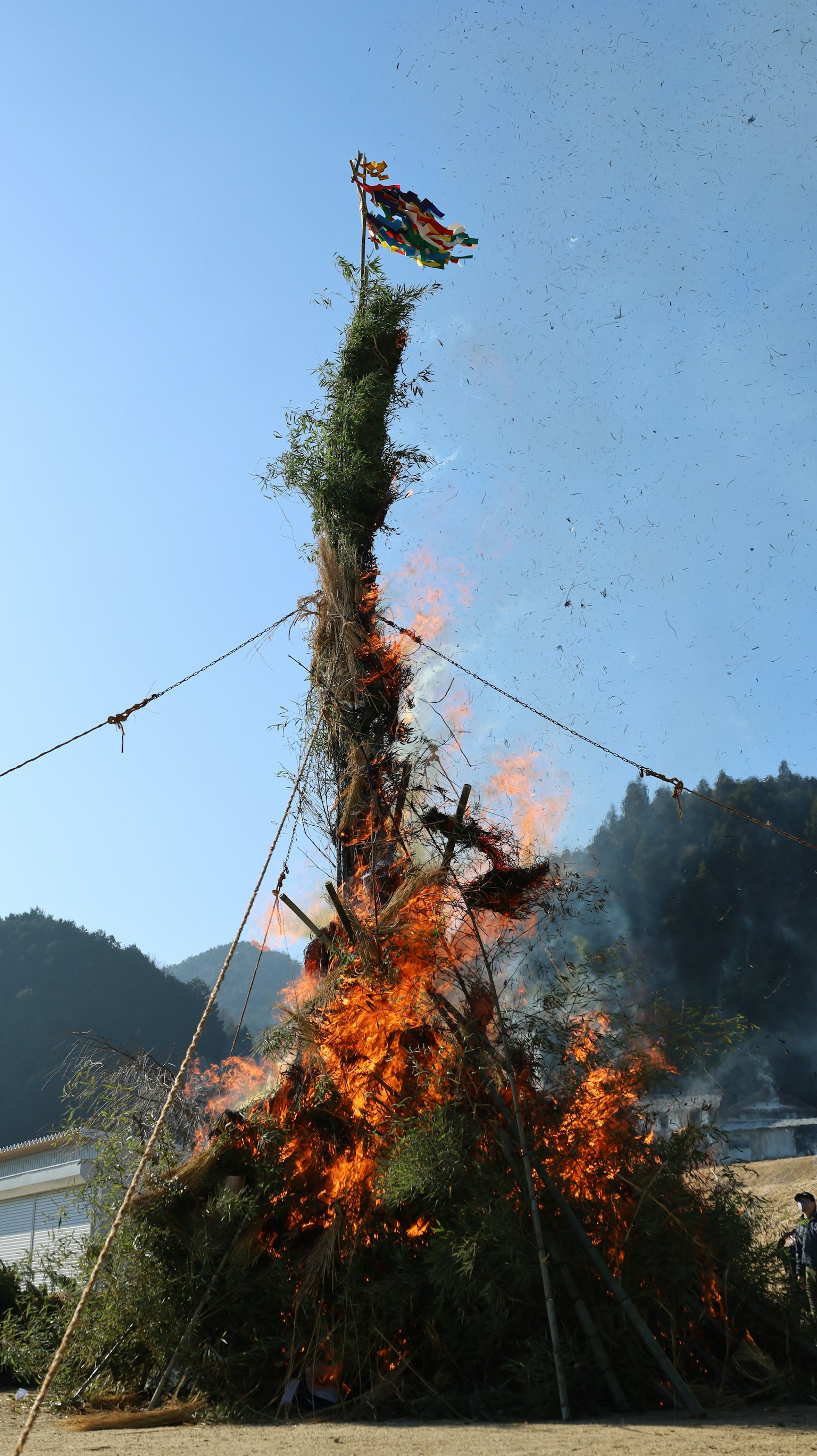 Eine hohe Struktur in Flammen unter einem klaren blauen Himmel