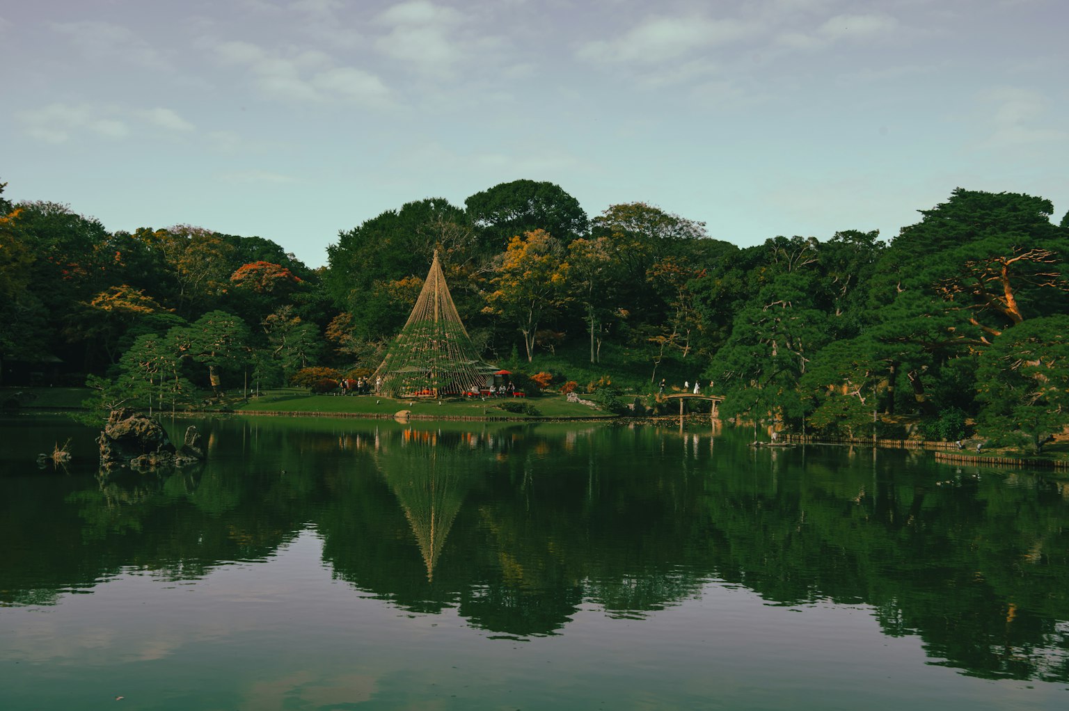 Vista escénica de una cabaña junto a un lago tranquilo rodeada de vegetación exuberante