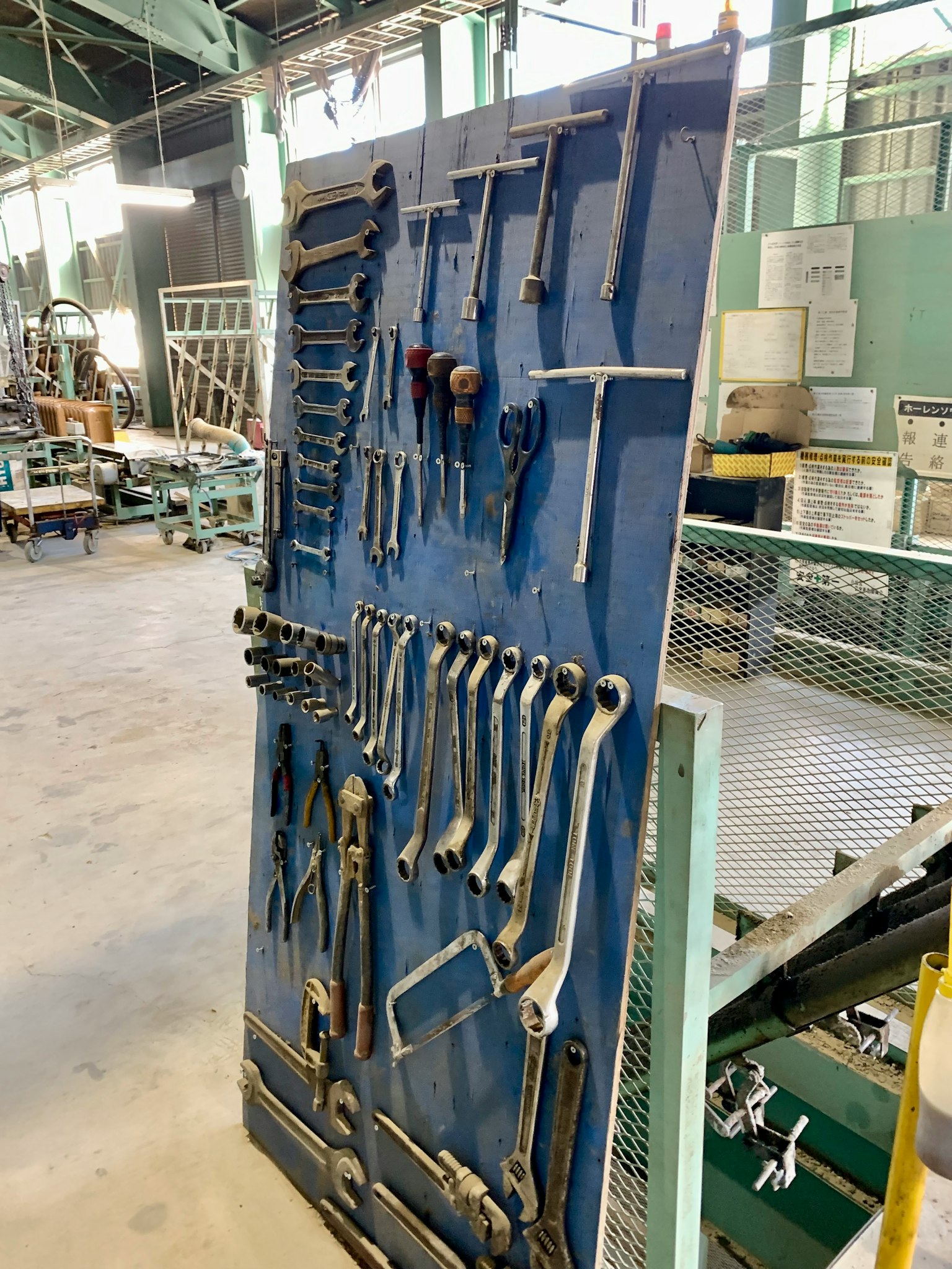 A blue panel displaying organized tools in a factory setting