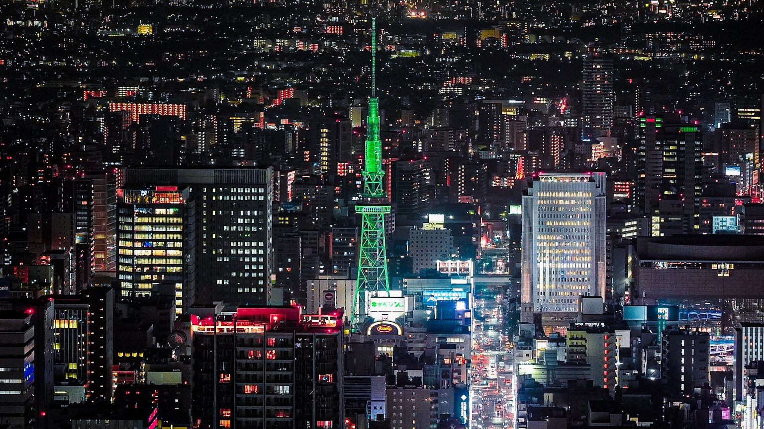 Tokyo Skytree illuminé en vert devant une skyline urbaine animée