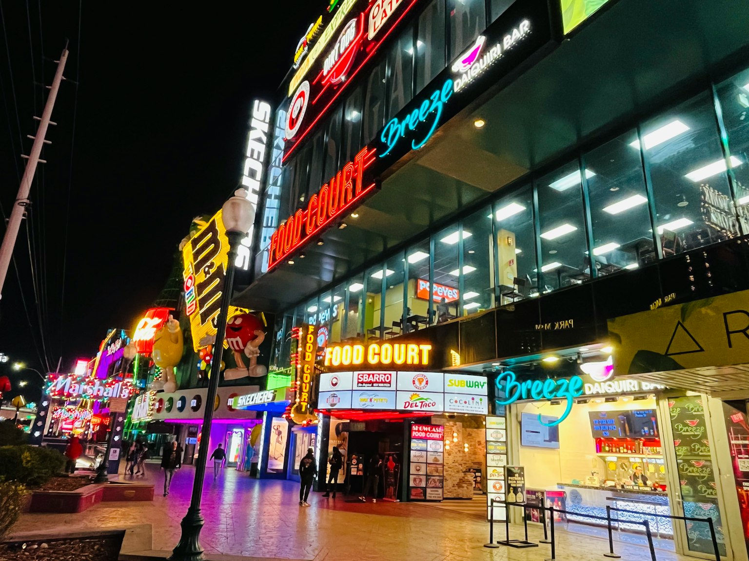 Scena notturna vivace con un food court e insegne al neon