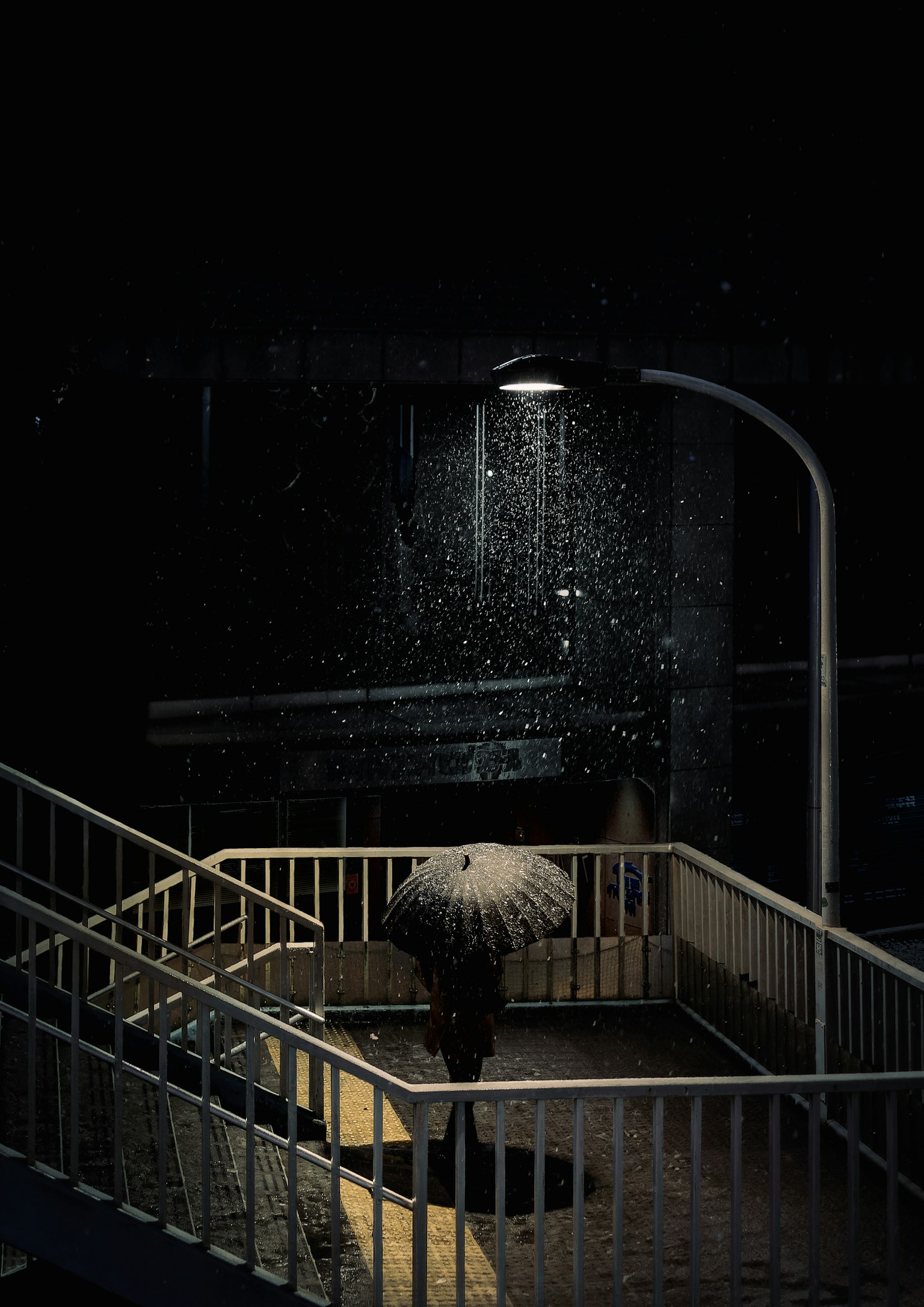 雨の中の傘と街灯のある階段の風景