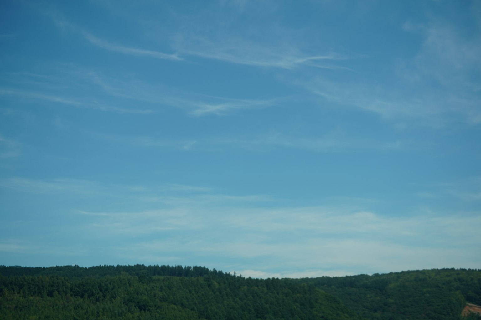 Ciel bleu avec des collines vertes en arrière-plan