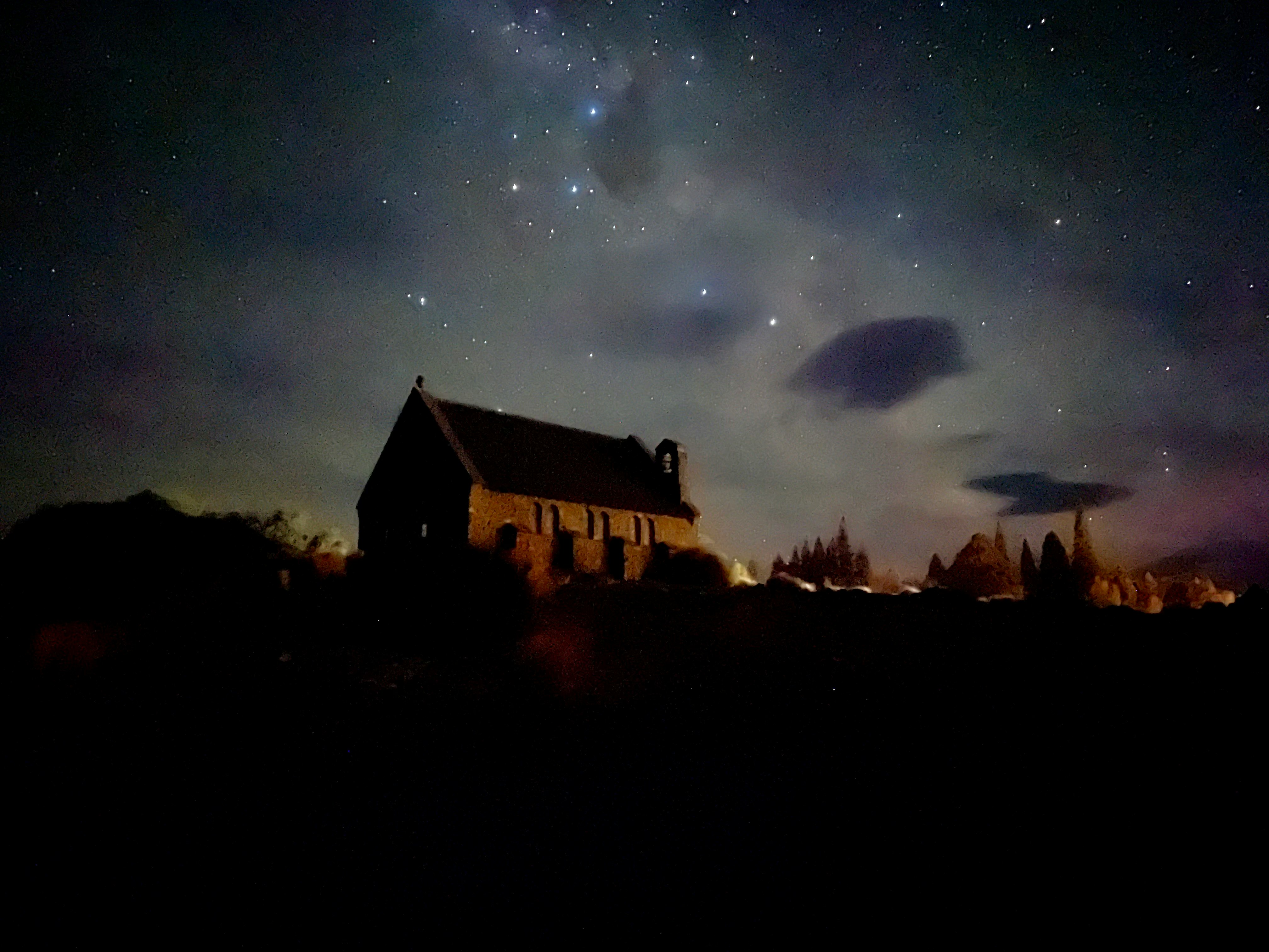 night sky stars over a hilltop observatory dome and cabin