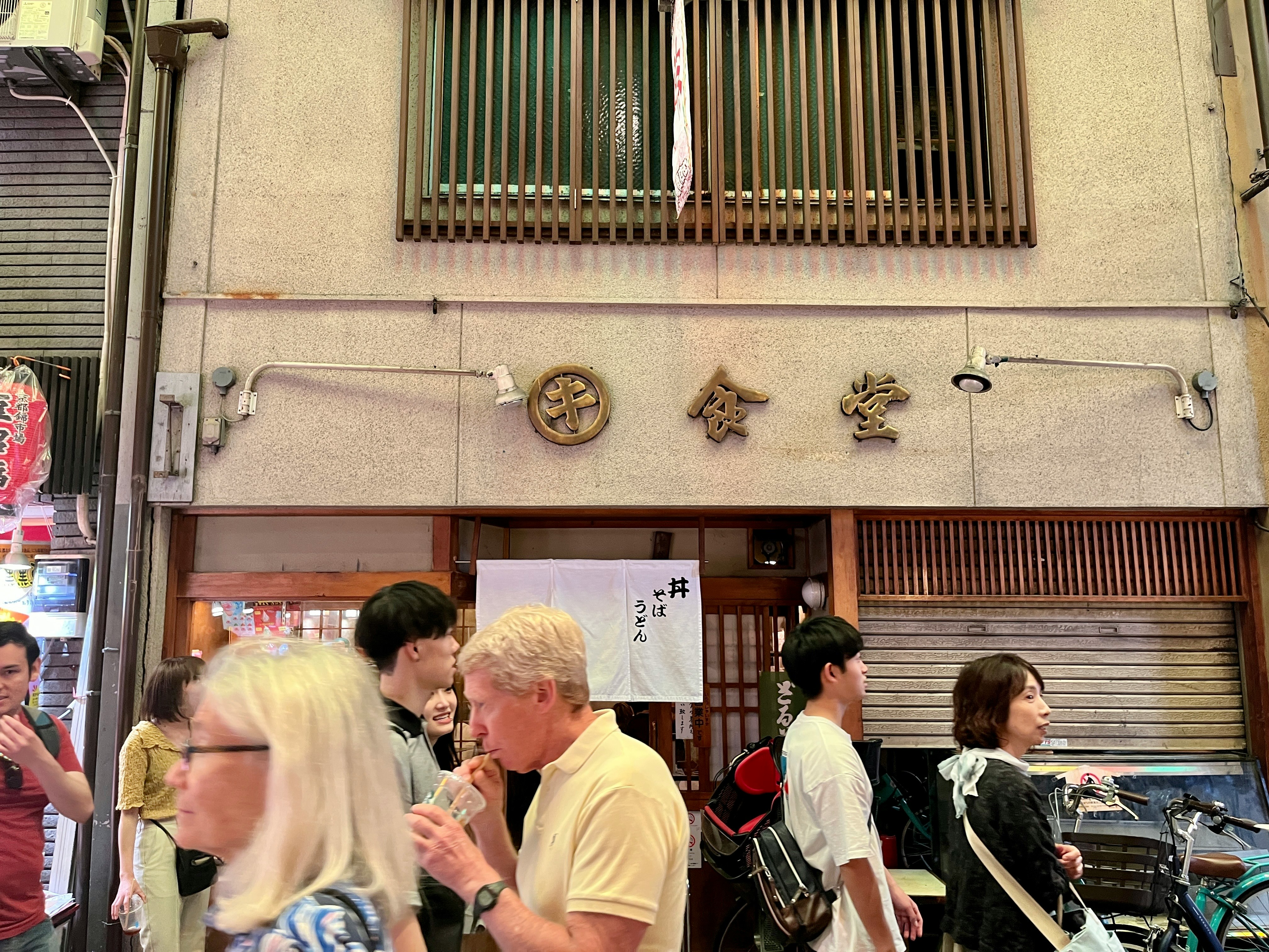 錦市場の食堂前で会話する人々と自転車