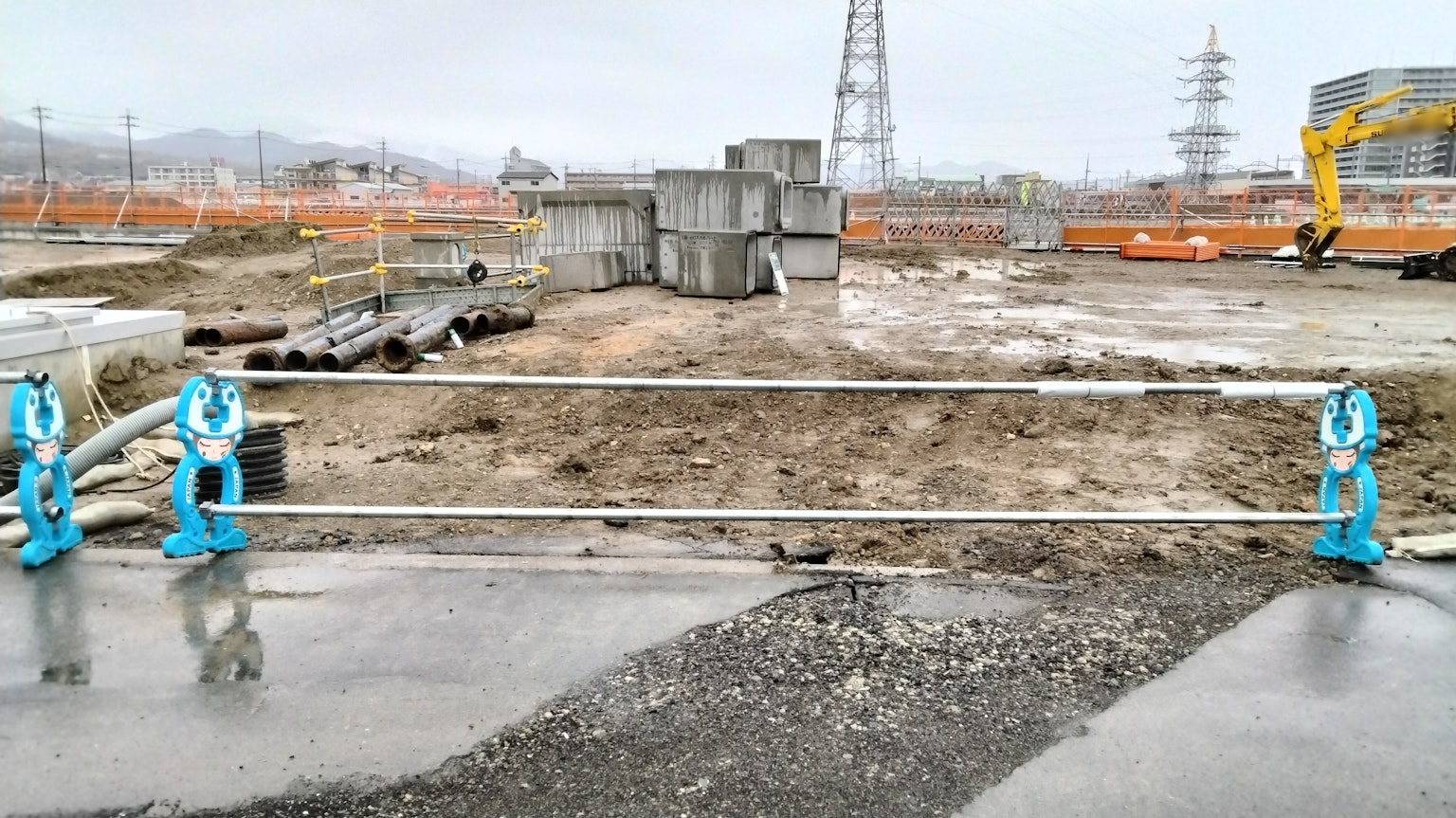 Sitio de construcción con barreras azules y pilas de bloques de concreto