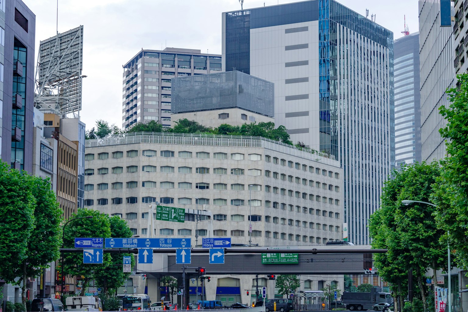 고층 빌딩에 둘러싸인 독특한 녹색 옥상 건물