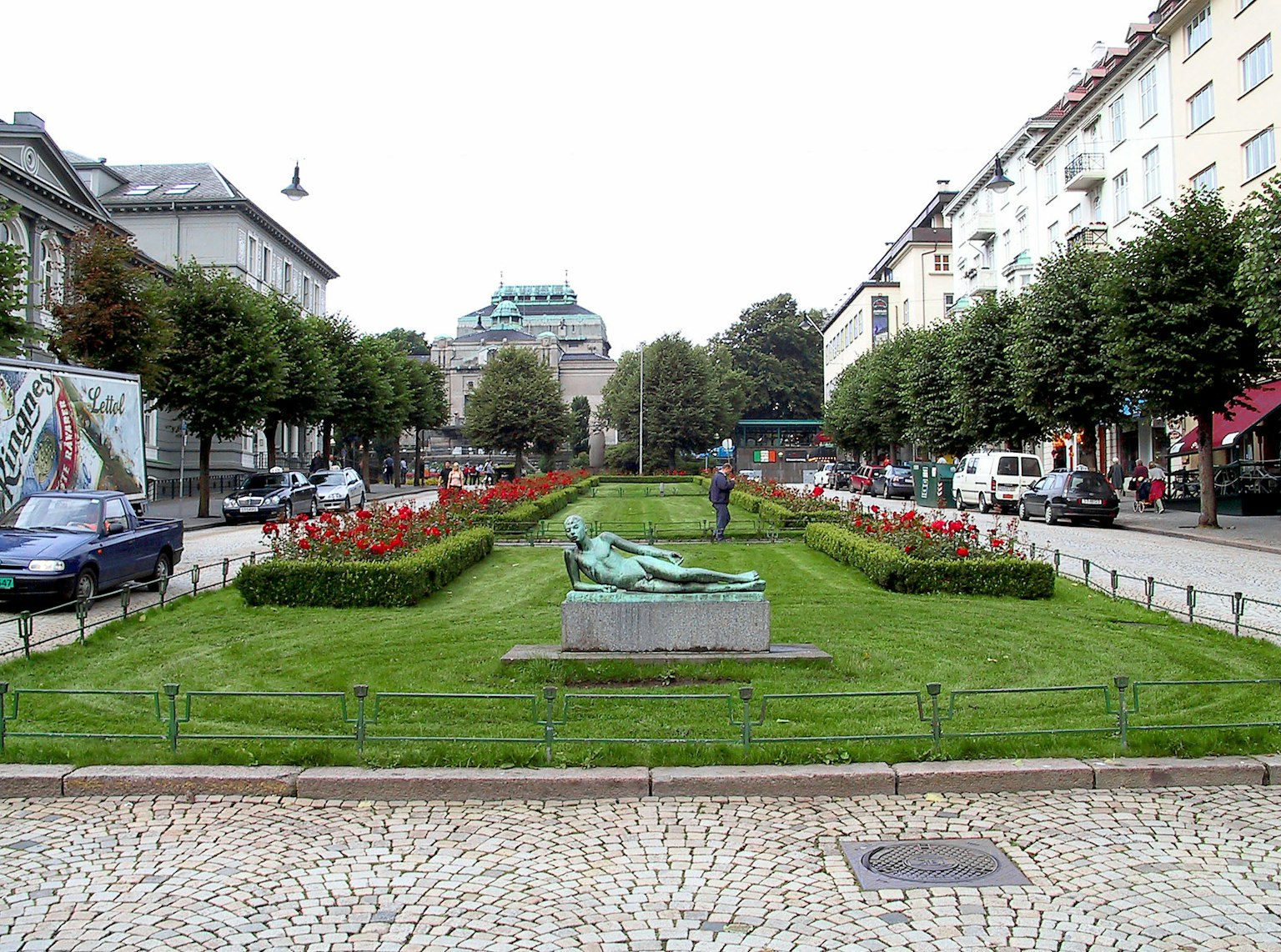 Scena di parco con una scultura e aiuole fiorite