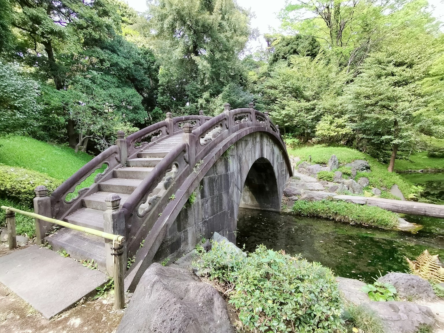Ponte ad arco in legno in un parco lussureggiante