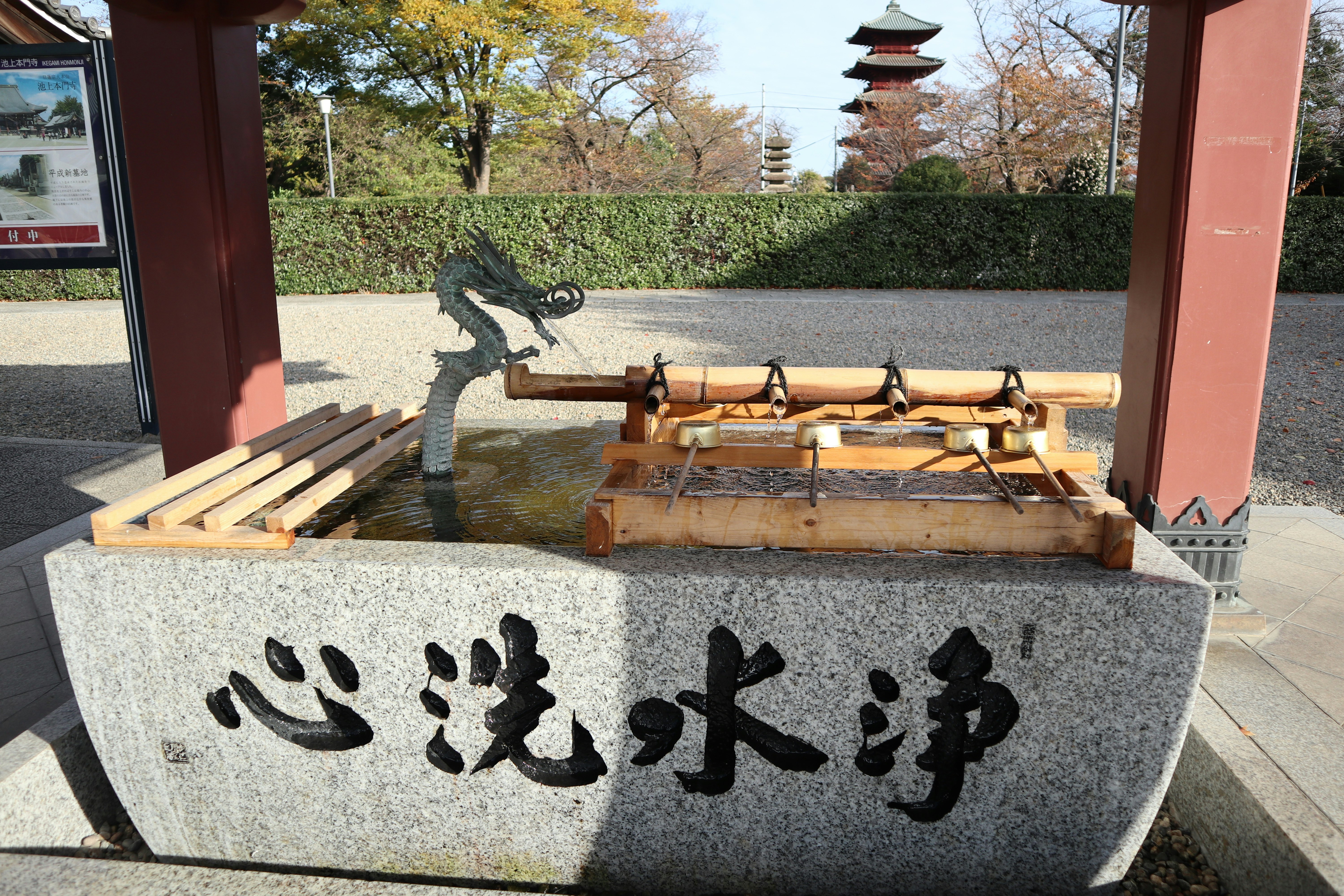 「いい井水浄」の文字が刻まれた手水鉢と竹の柄杓