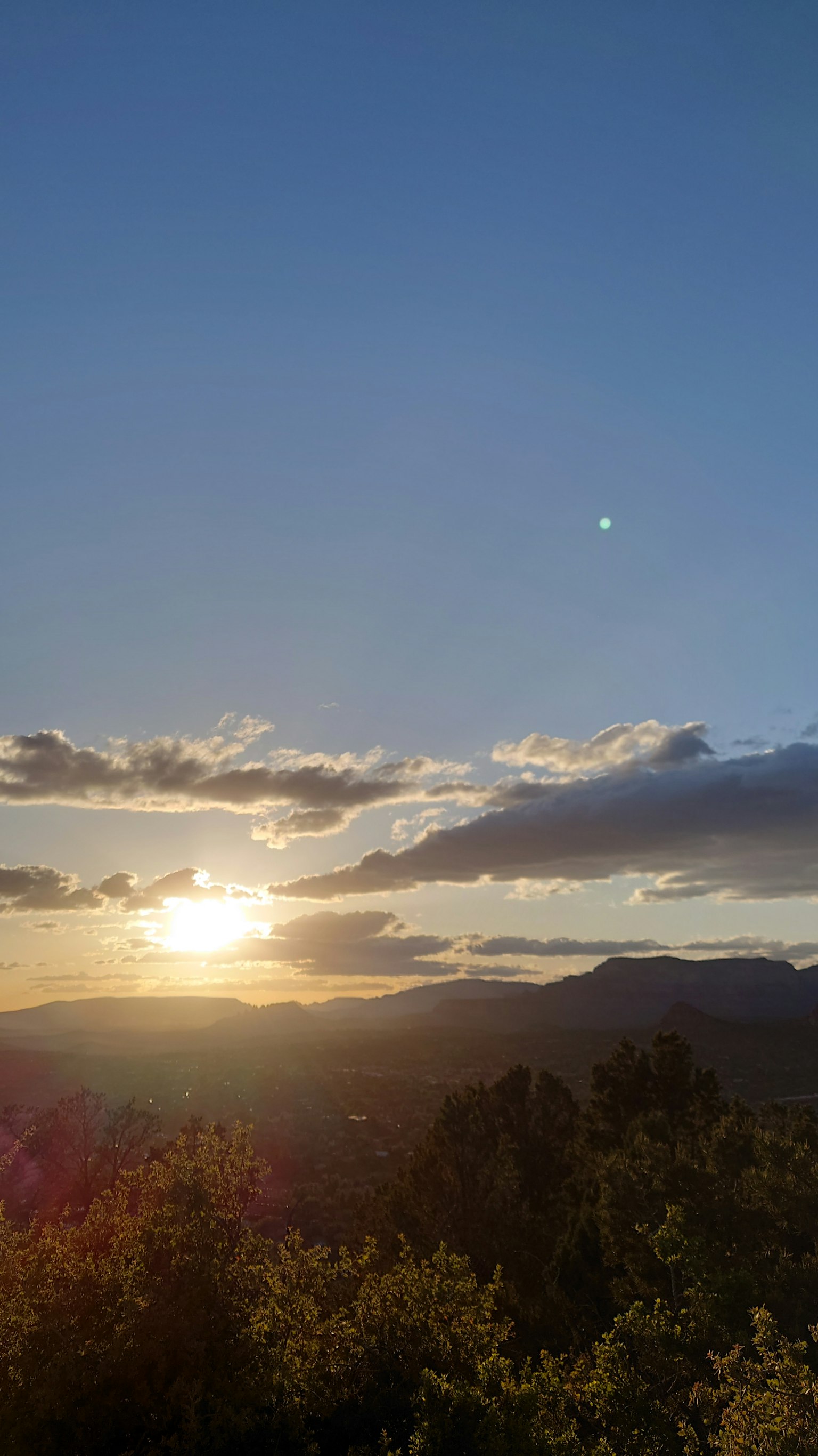 Sunset over mountains with blue sky and clouds