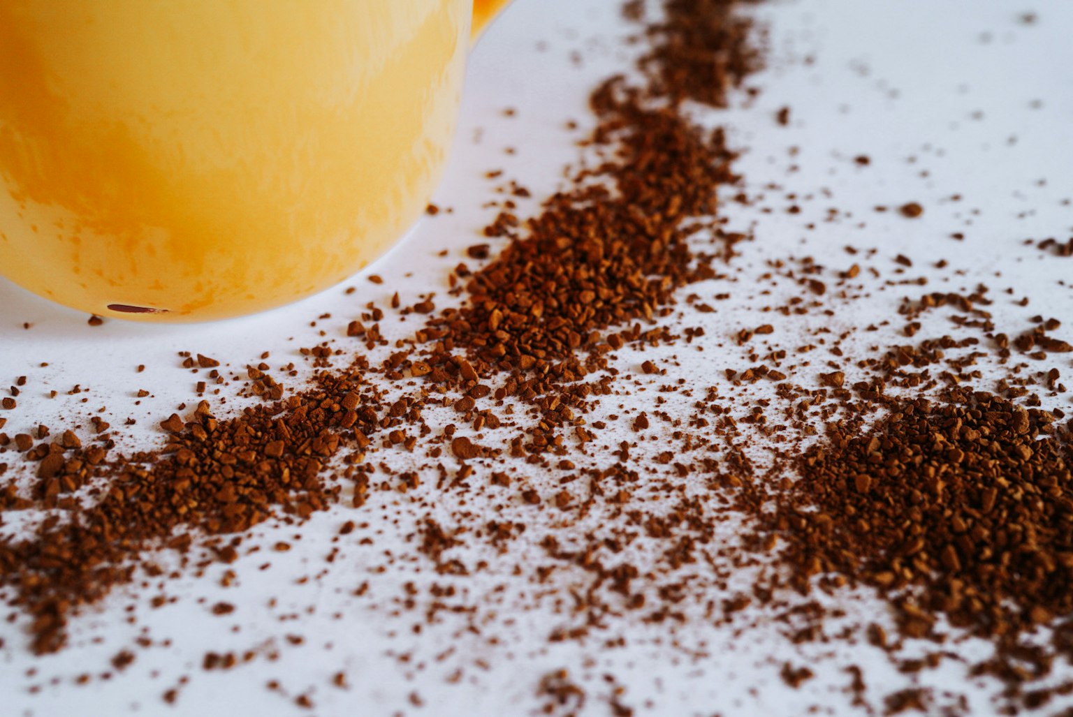 Close-up kopi bubuk dengan cangkir oranye