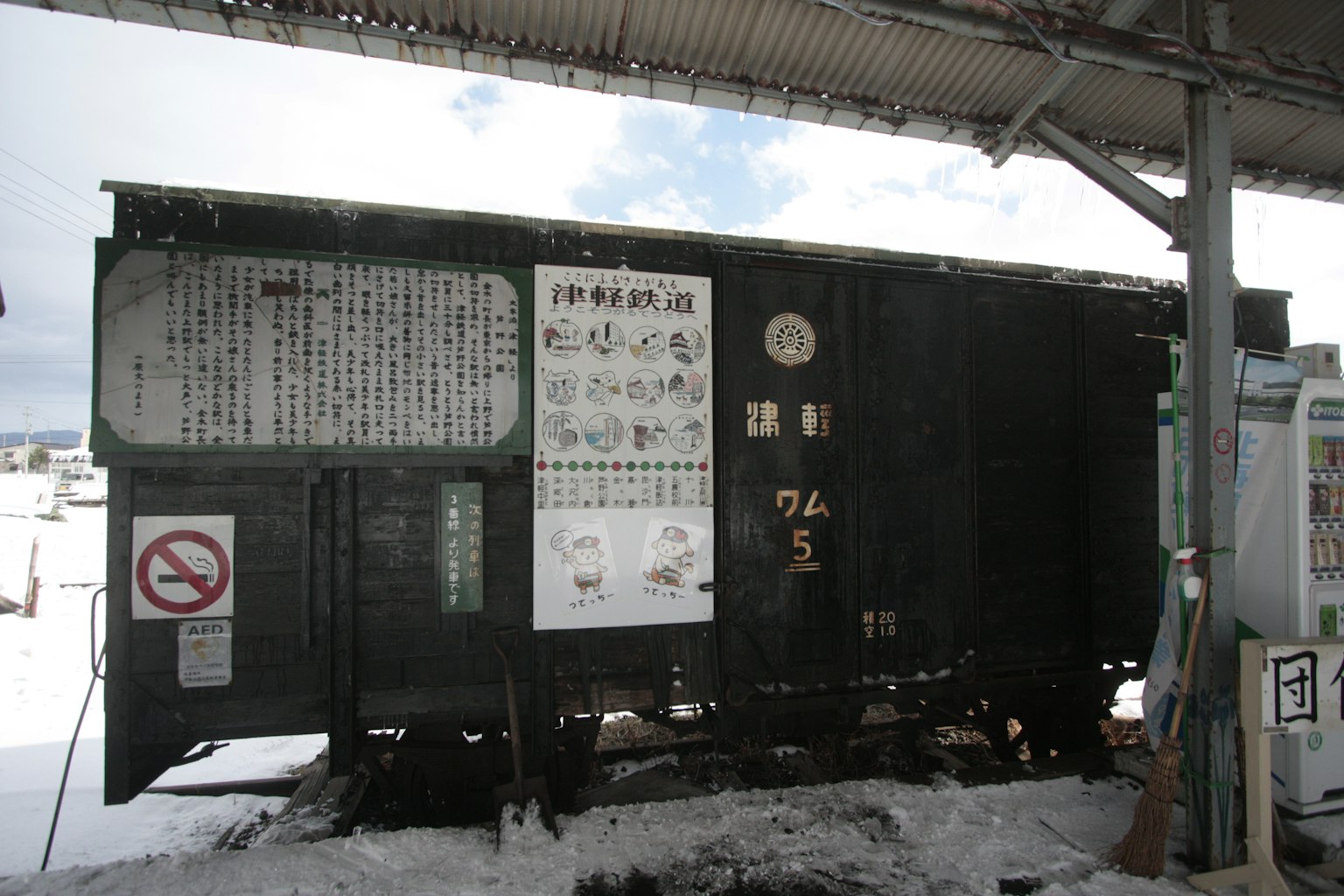 雪地车站的旧绿色火车车厢和信息标志