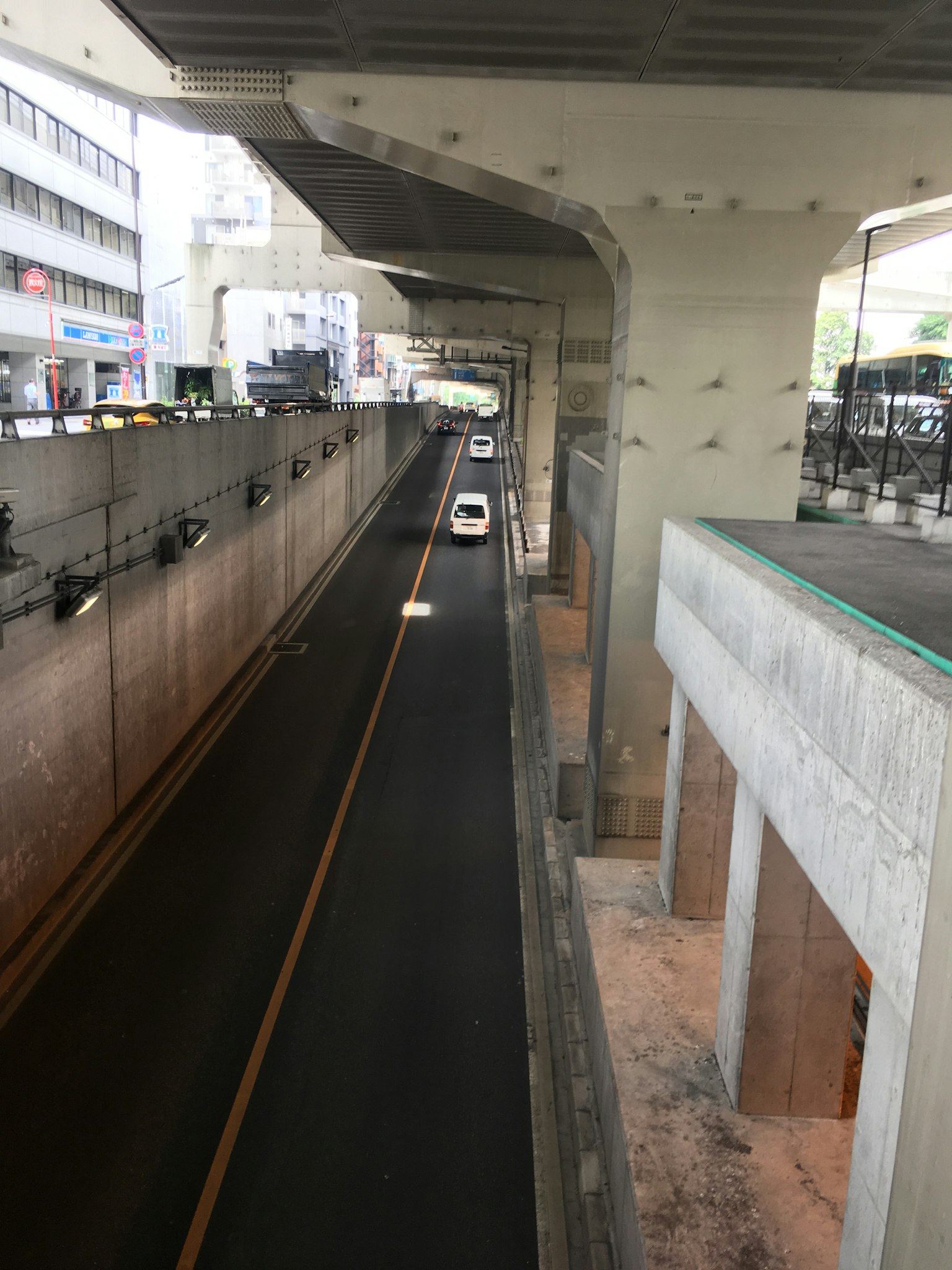 Pemandangan jalan di bawah struktur tinggi dengan mobil yang melintas