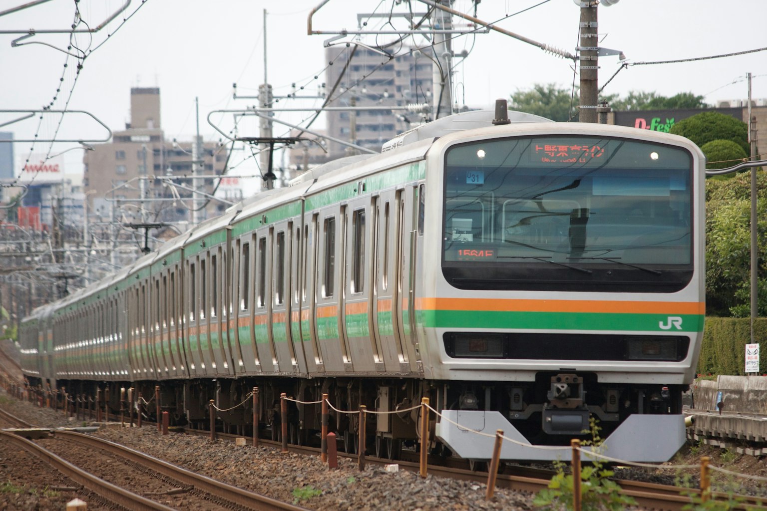 Ein japanischer Zug mit grünen und orangefarbenen Streifen in Bewegung