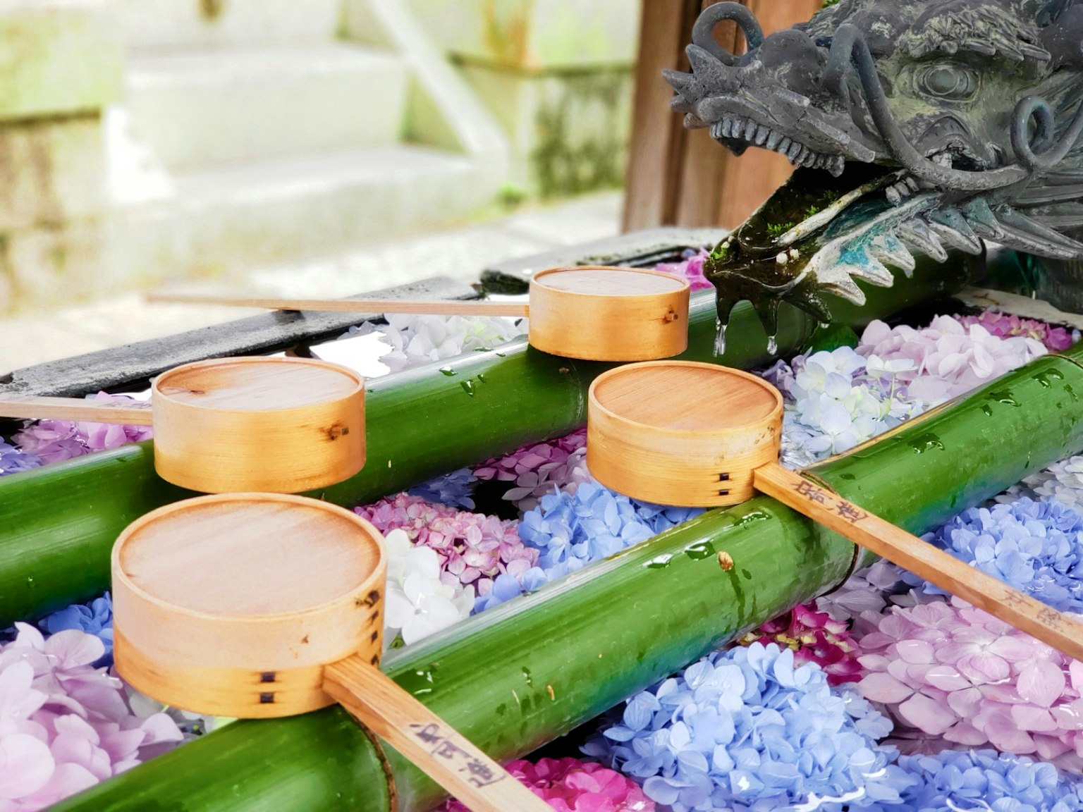 Wadah kayu di atas bambu dengan kelopak bunga dan air