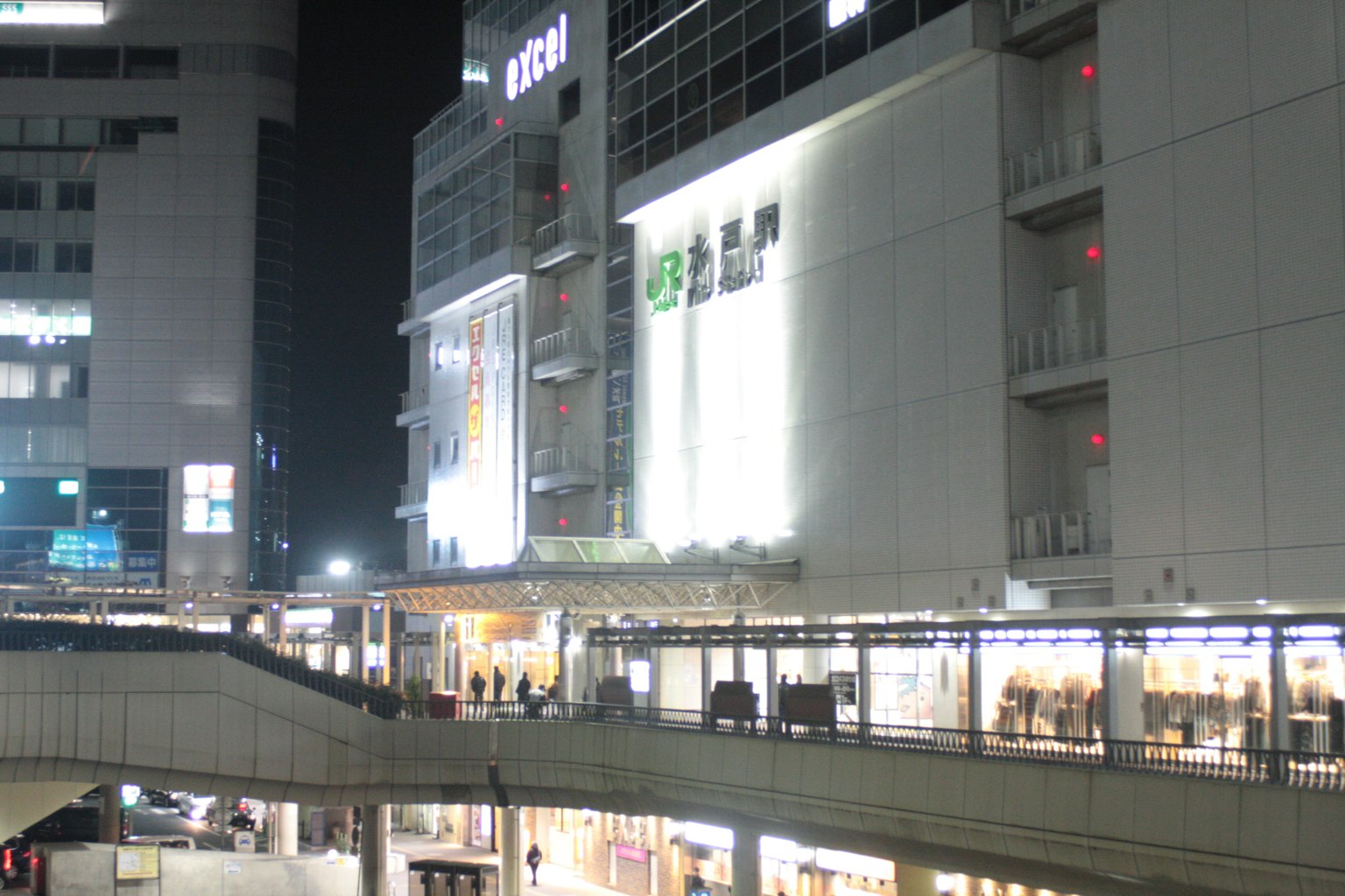 Night view of cityscape featuring illuminated storefronts