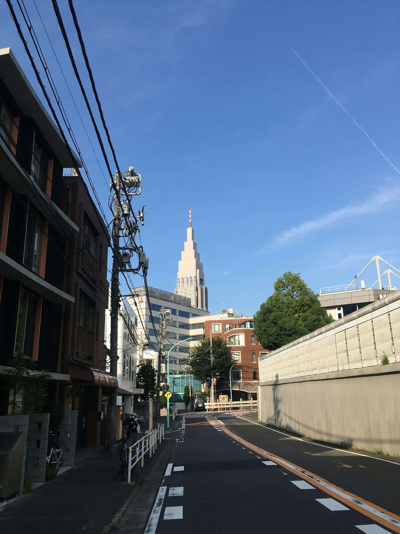 Street view with Shinjuku skyscraper under blue sky