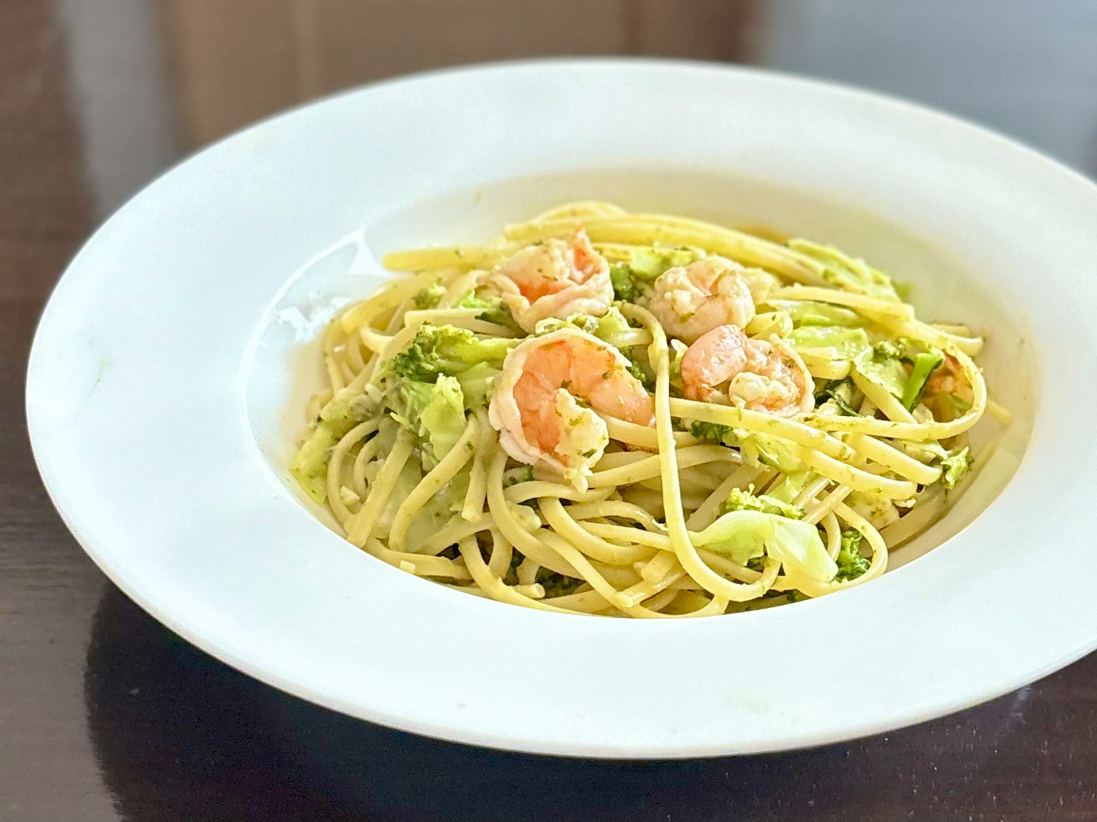 Piatto di pasta con gamberi e cavolo servito su un piatto bianco