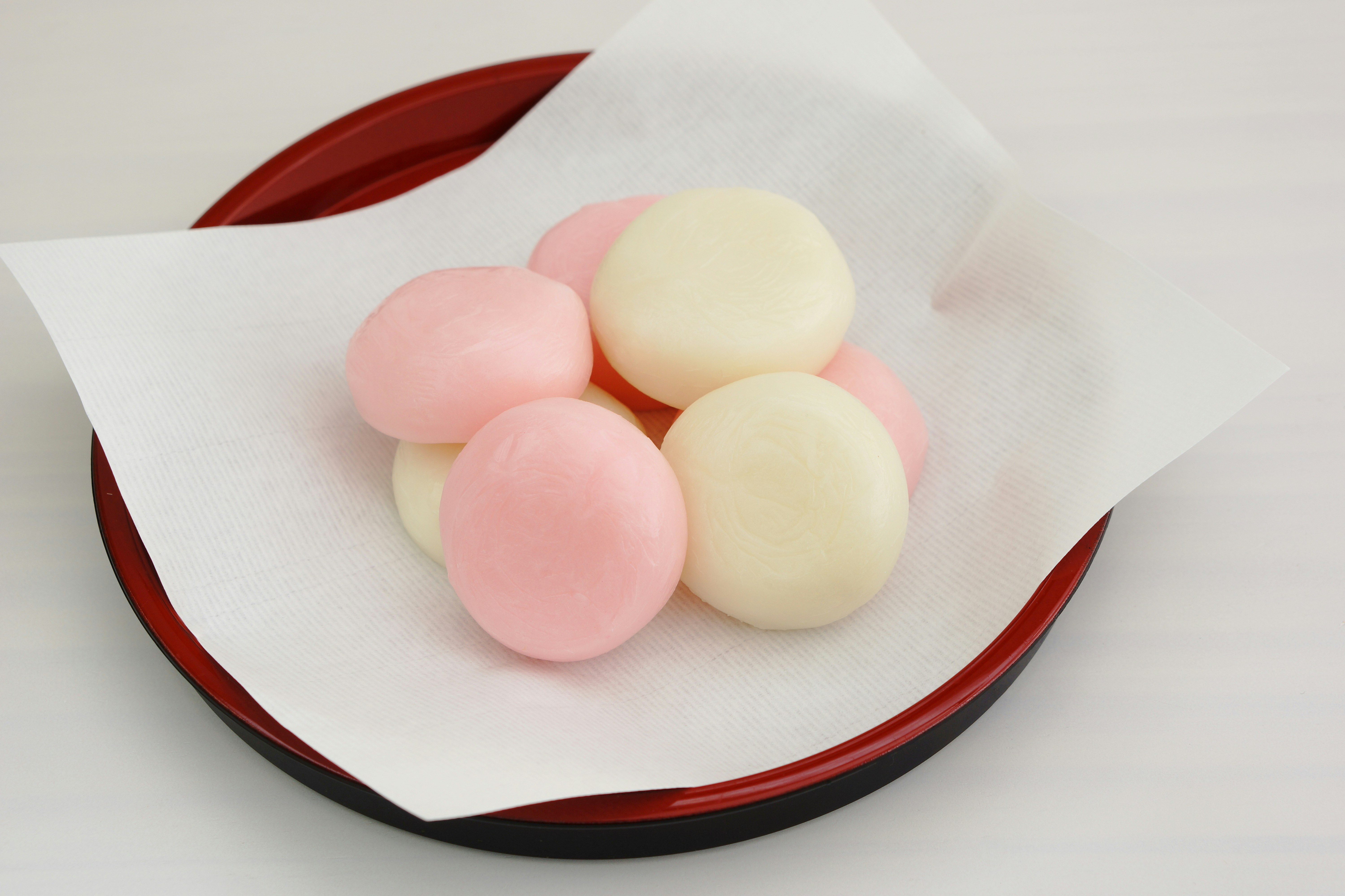 白い紙の上に並ぶピンクと白の和菓子