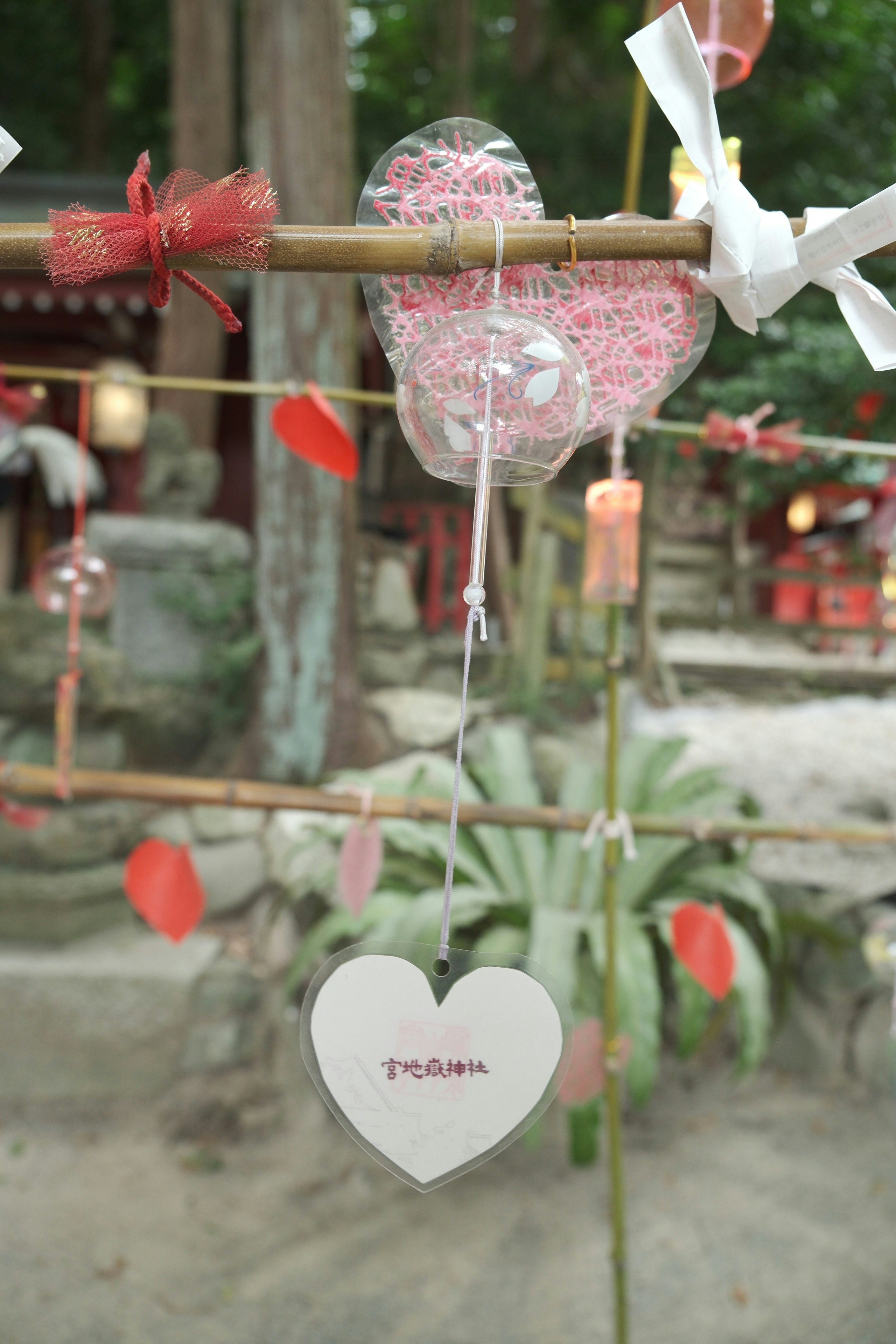 風鈴の飾りとハートの紙飾りが揺れる神社の参道