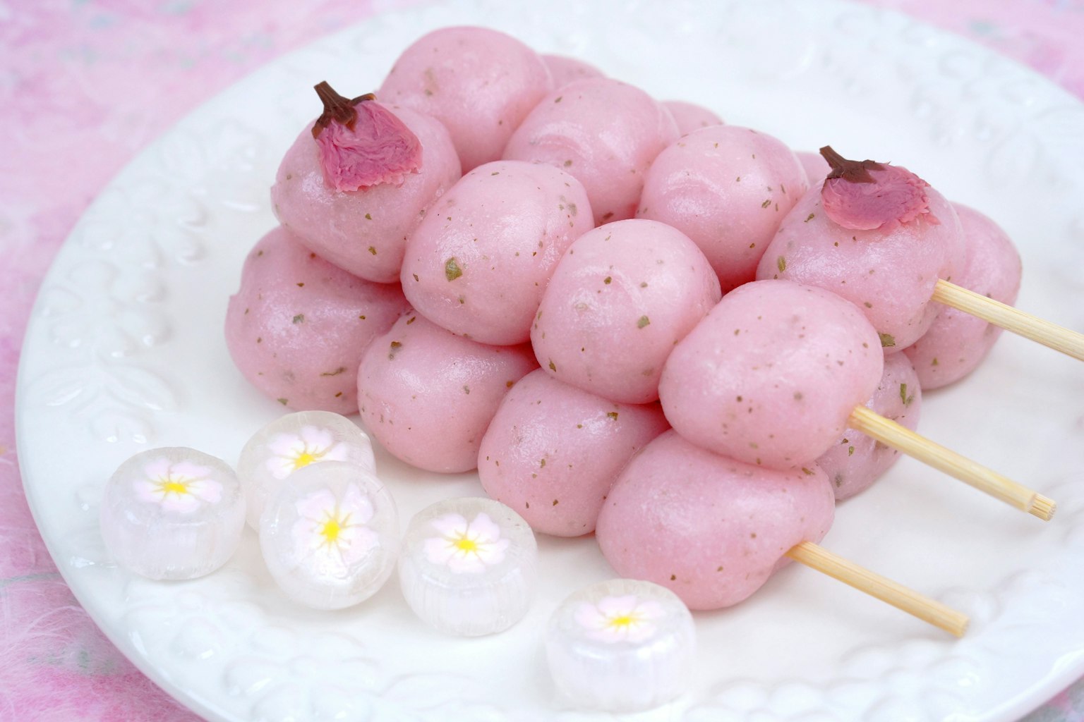 Bánh ngọt màu hồng nhạt được xiên trên que và phục vụ trên đĩa