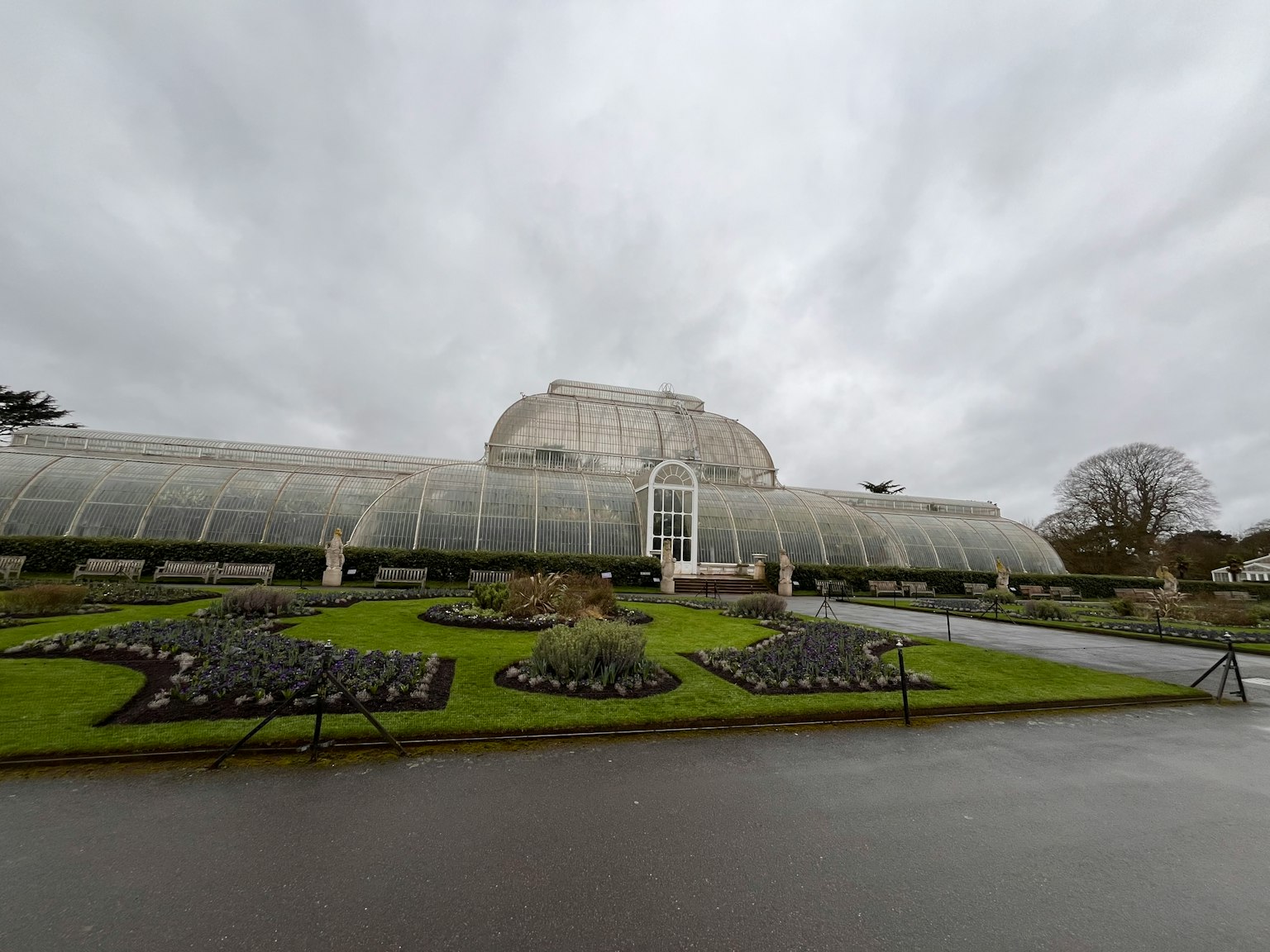 Exterior view of a glasshouse and surrounding garden