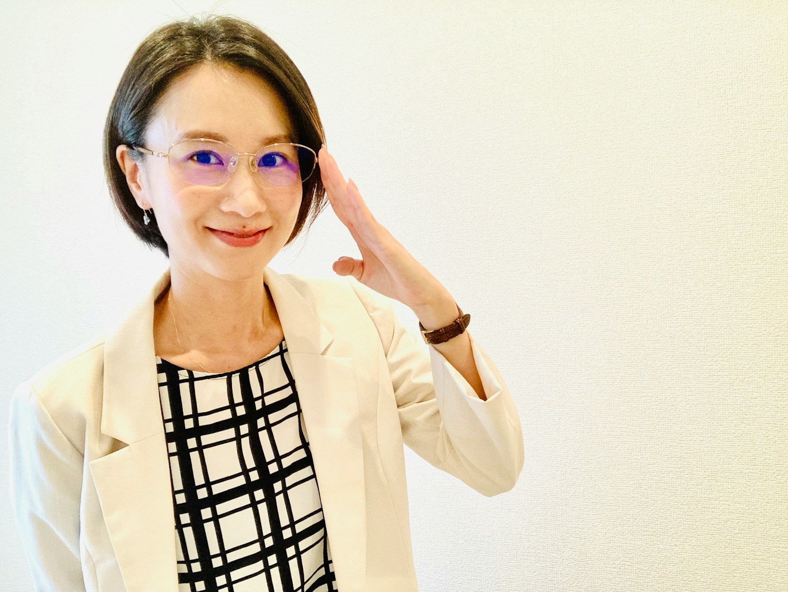 在白色背景前微笑并举手的女性 穿着条纹衬衫和夹克