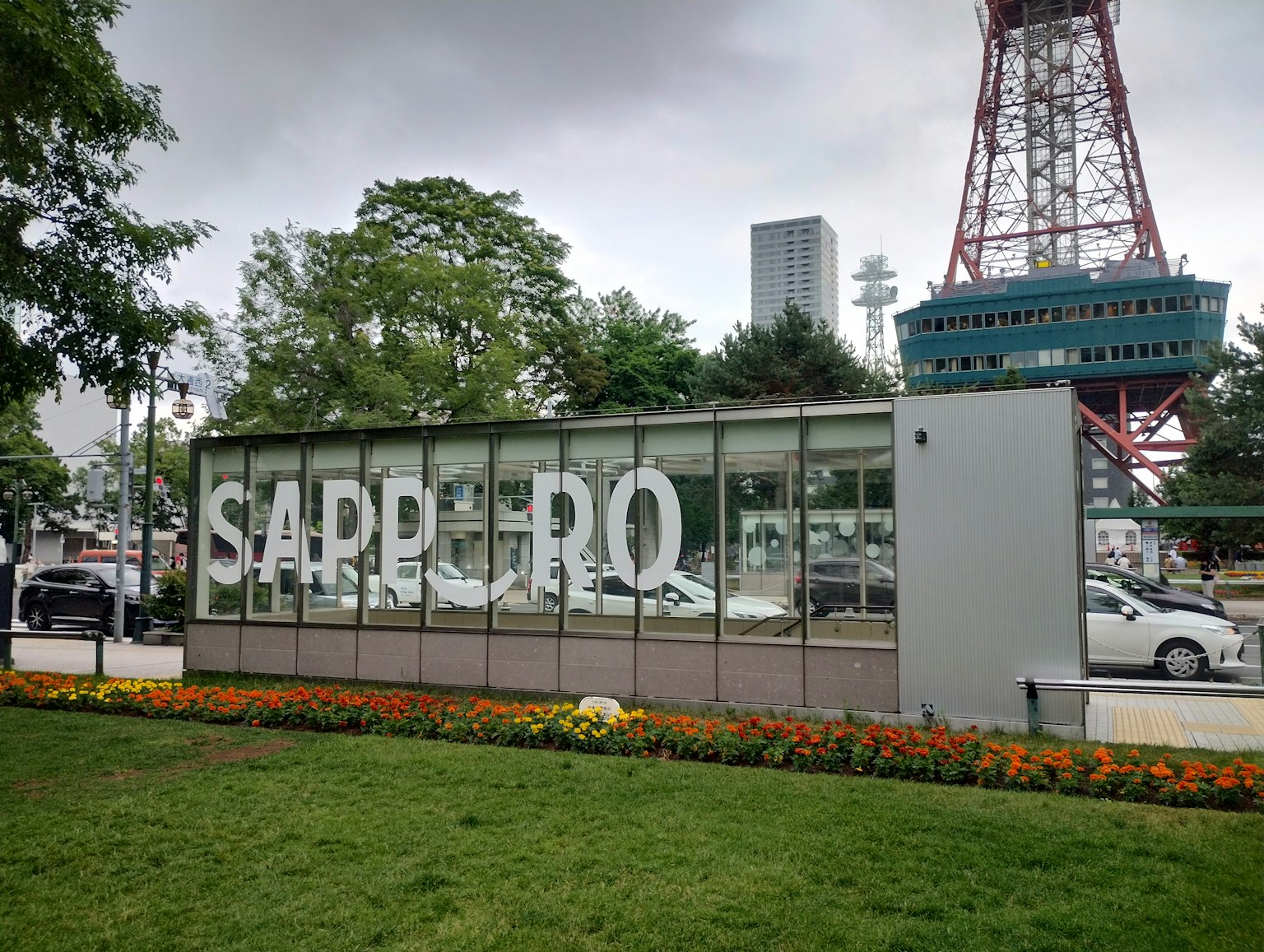 Cartel de Sapporo con flores y la Torre de TV de Sapporo al fondo