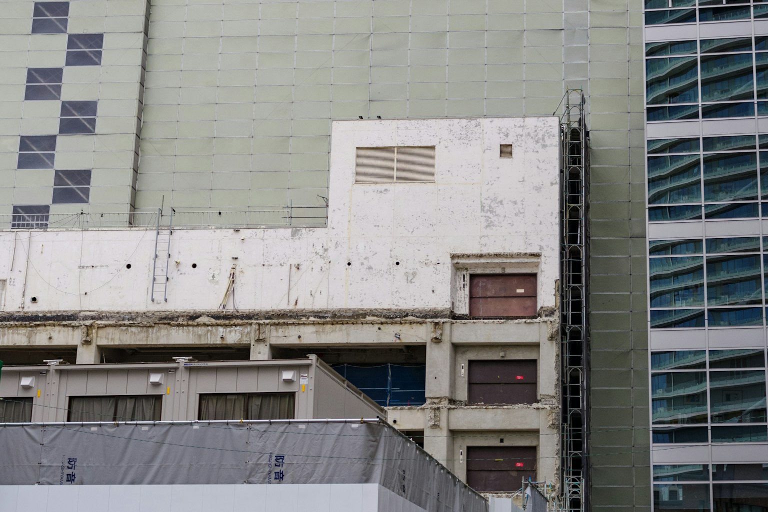 Scène urbaine montrant le contraste entre une façade de bâtiment ancien et une structure moderne