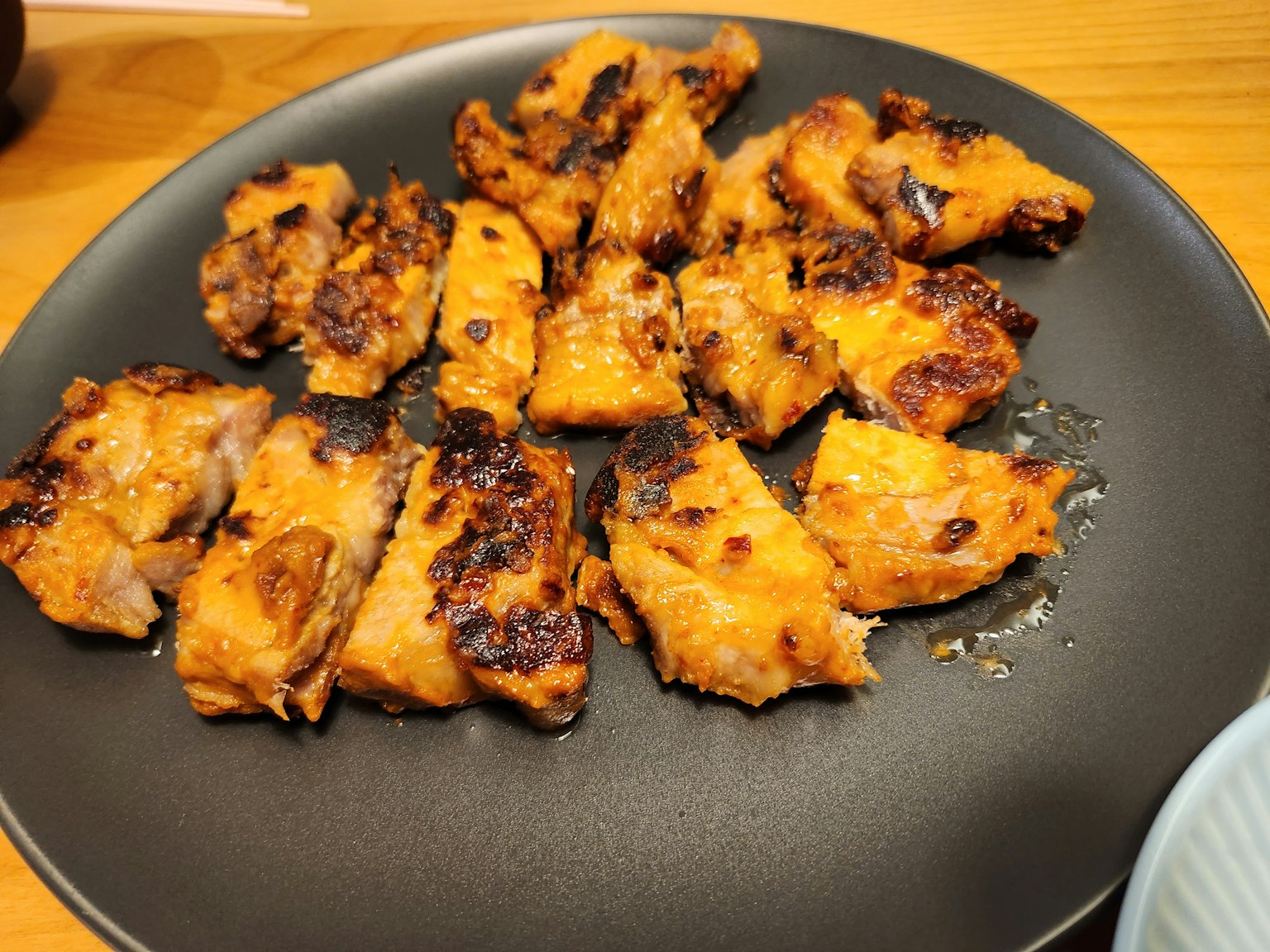Piring berisi potongan ayam bakar dengan permukaan renyah