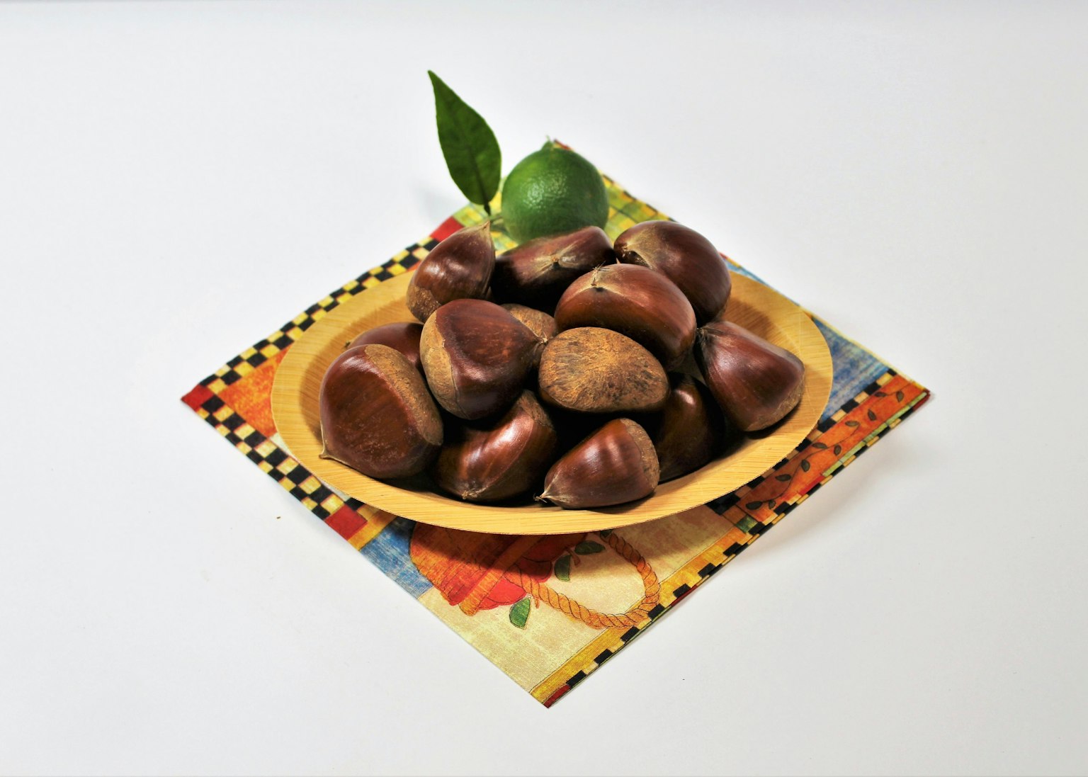 Un plato de castañas con una hoja de lima