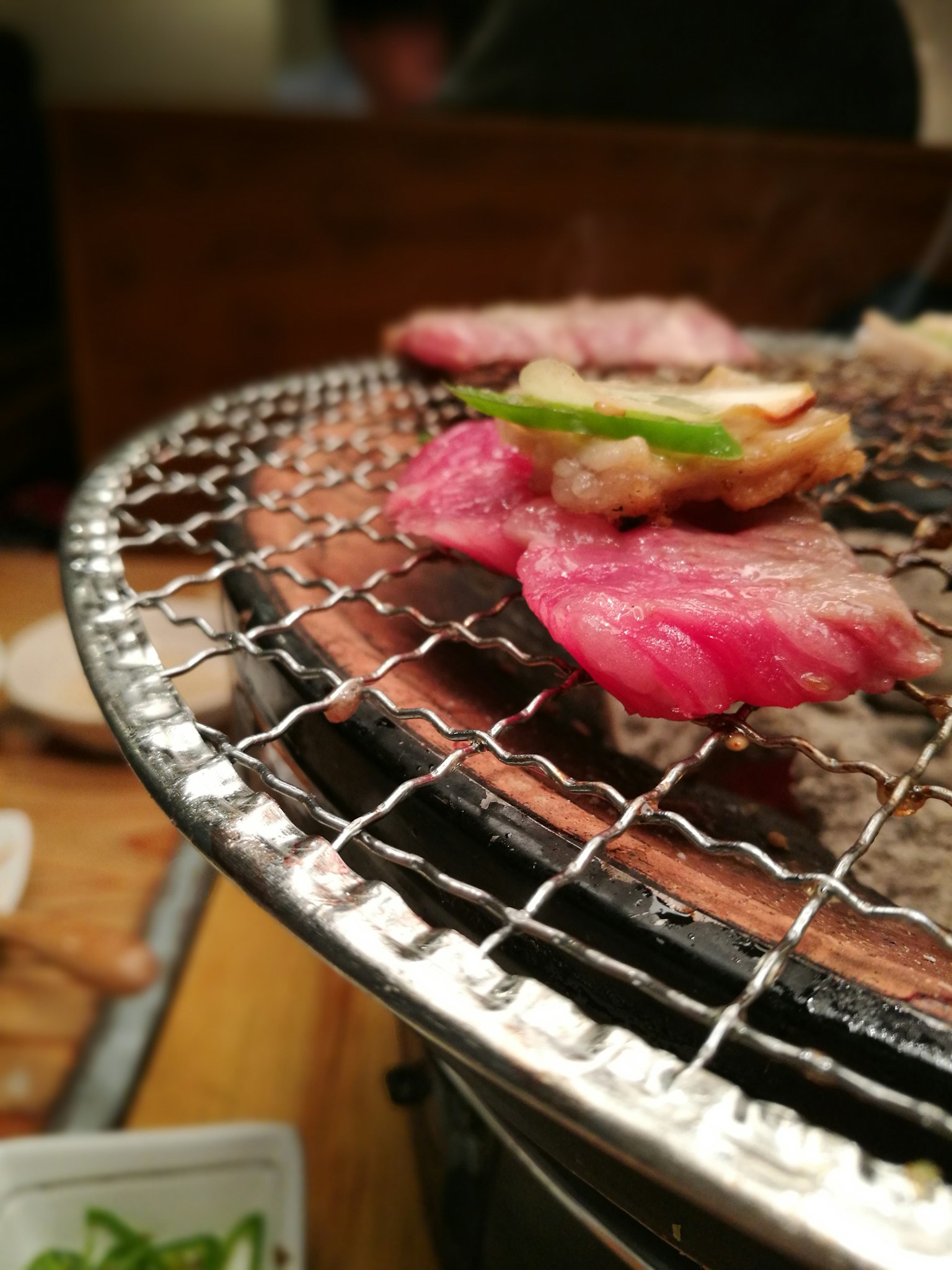 Fette di carne e cipollotti su una griglia per barbecue