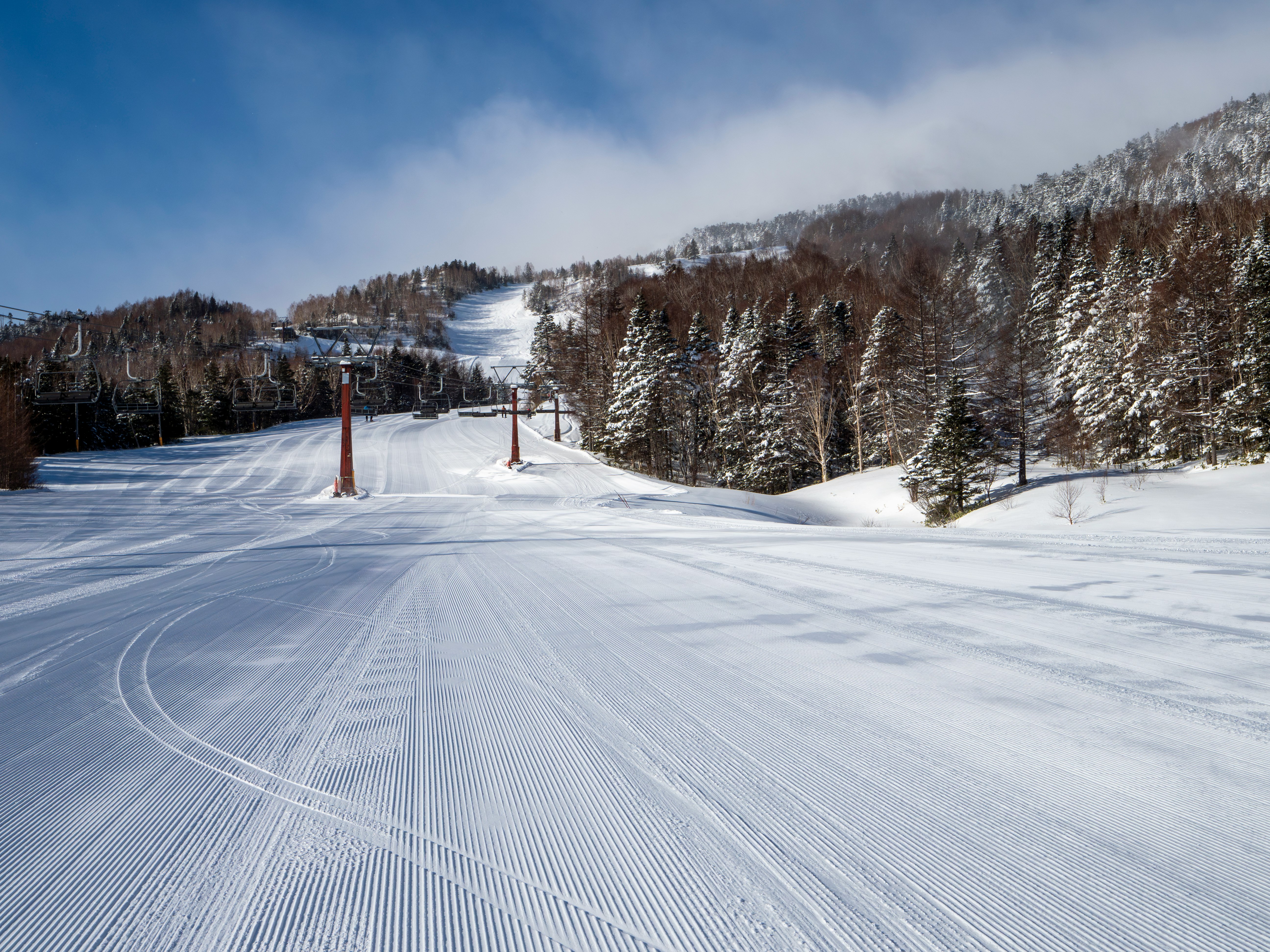 青空の乗鞍高原スキー場ゲレンデと雪の滑走路