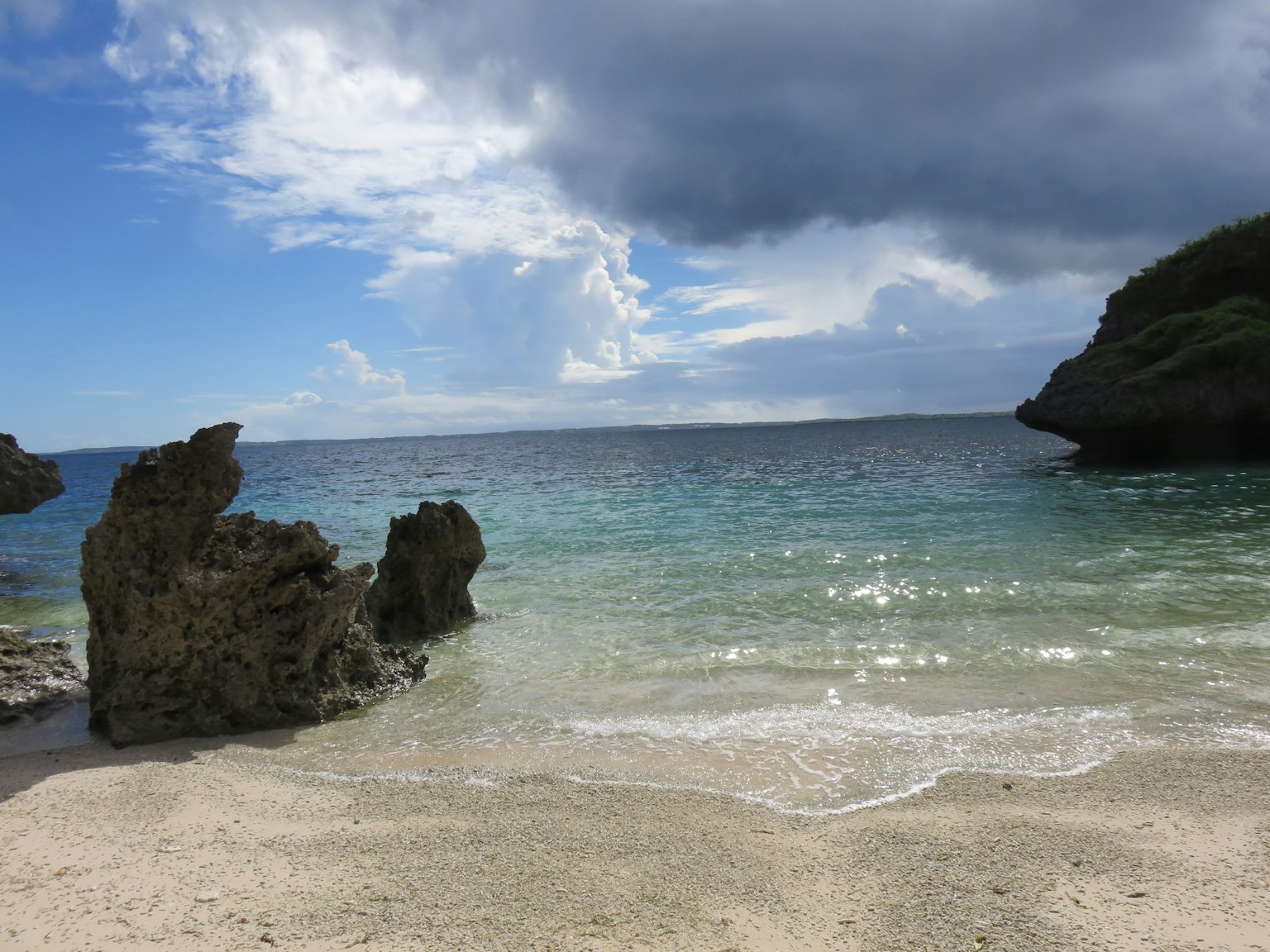 Vista panoramica dell'oceano blu e della spiaggia di sabbia bianca con rocce sparse