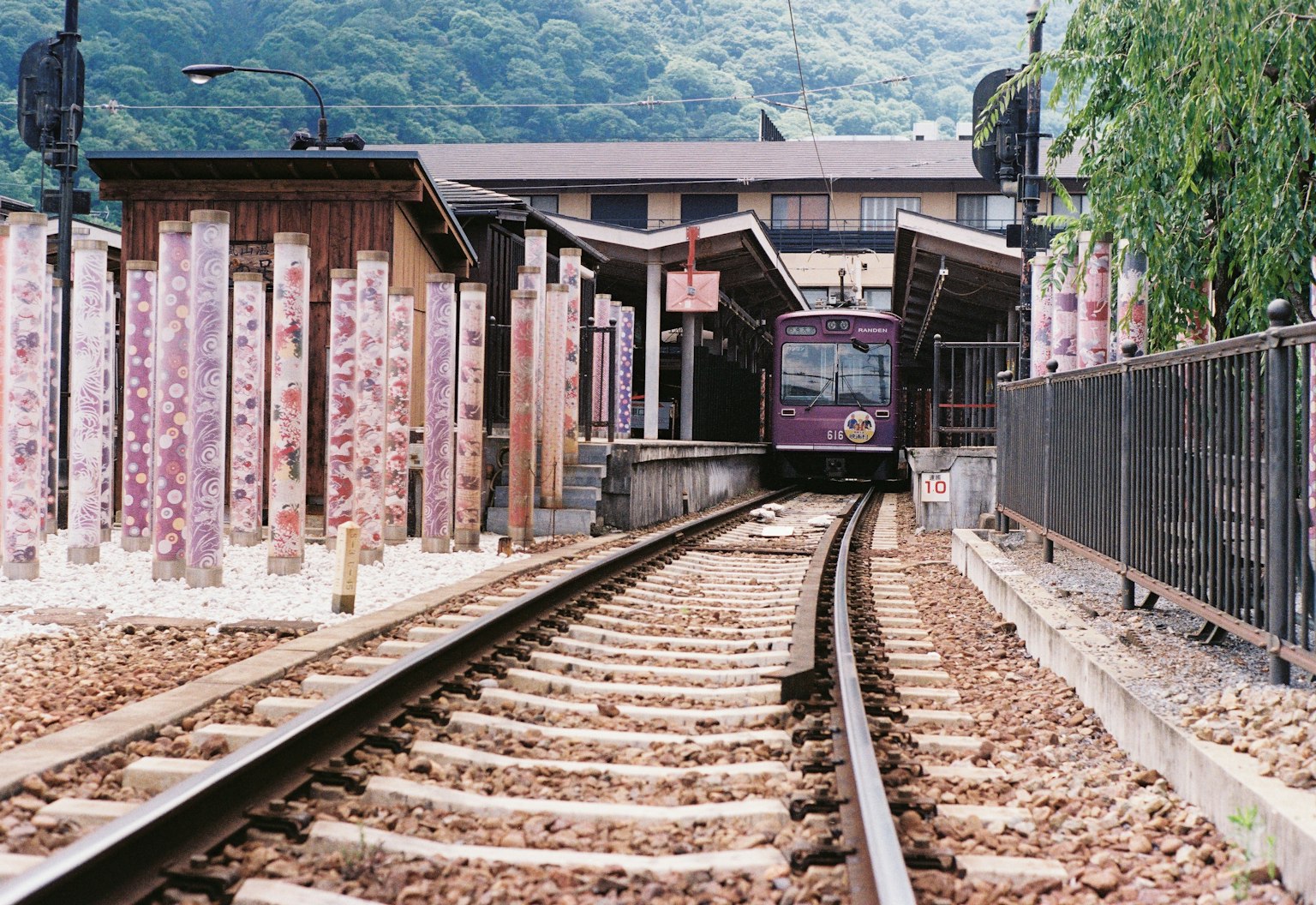 Train arriving at a mountain station with wooden platform